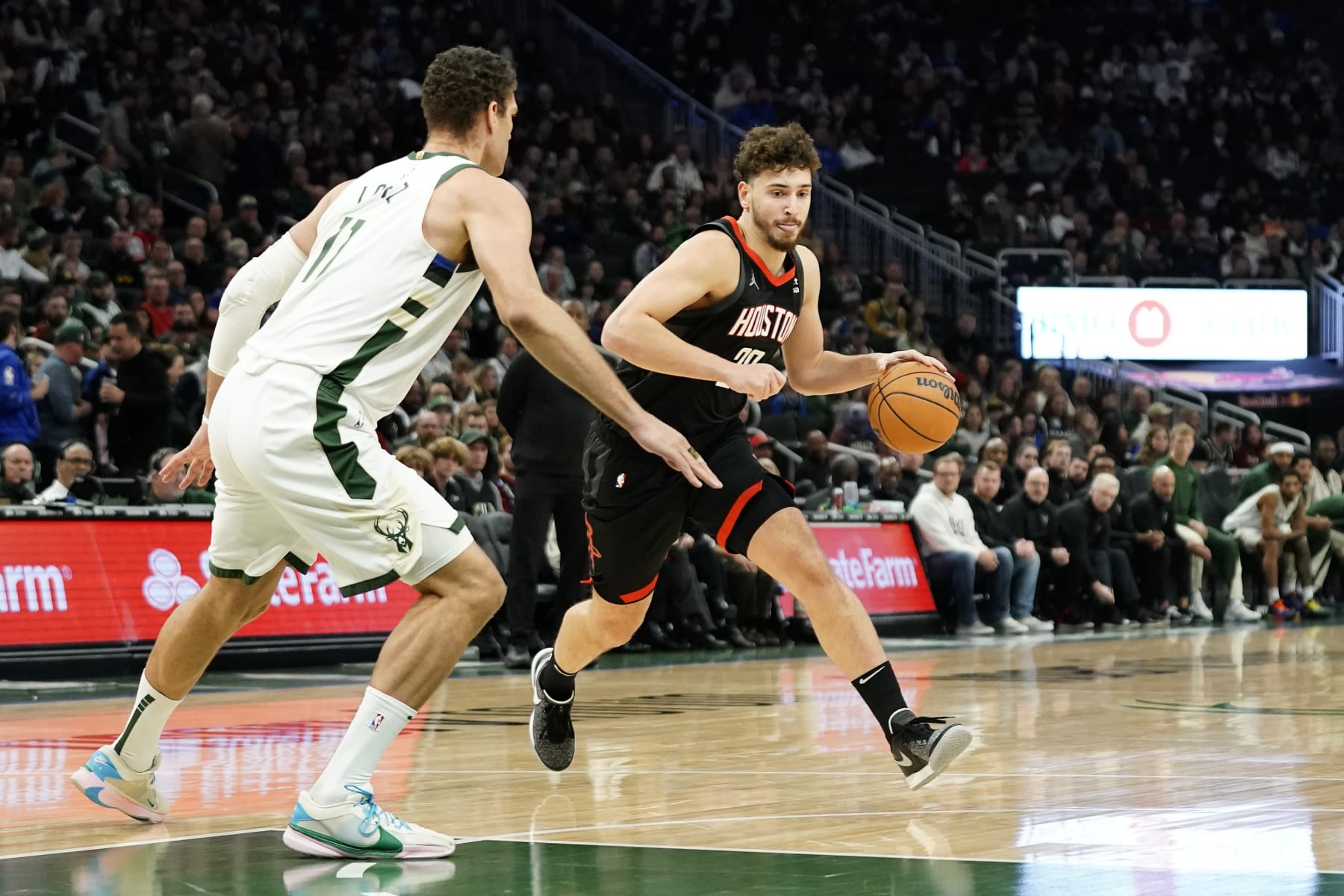 Houston Rockets' Alperen Sengun drives to the basket against Milwaukee Bucks' Brook Lopez during the first half of an NBA basketball game Sunday, Dec. 17, 2023, in Milwaukee. (AP Photo/Aaron Gash)