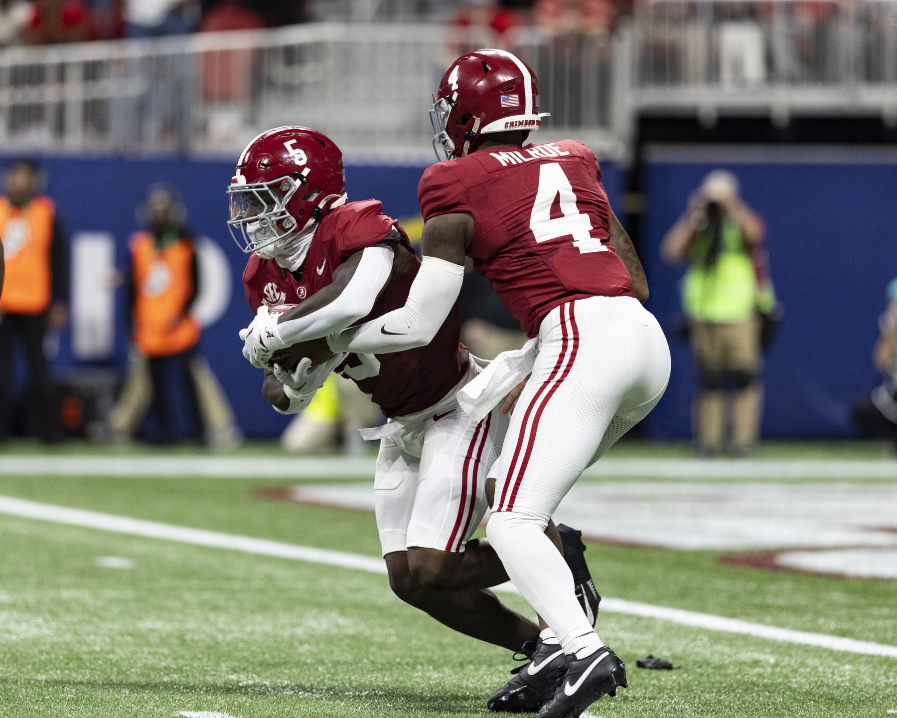 ATLANTA, GEORGIA - DECEMBER 2: Jalen Milroe #4 hands the ball off to Roydell Williams #5 of the Alabama Crimson Tide during a game between University of Georgia and University of Alabama at Mercedes-Benz Stadium on December 2, 2023 in Atlanta, Georgia. (Photo by Steve Limentani/ISI Photos/Getty Images)