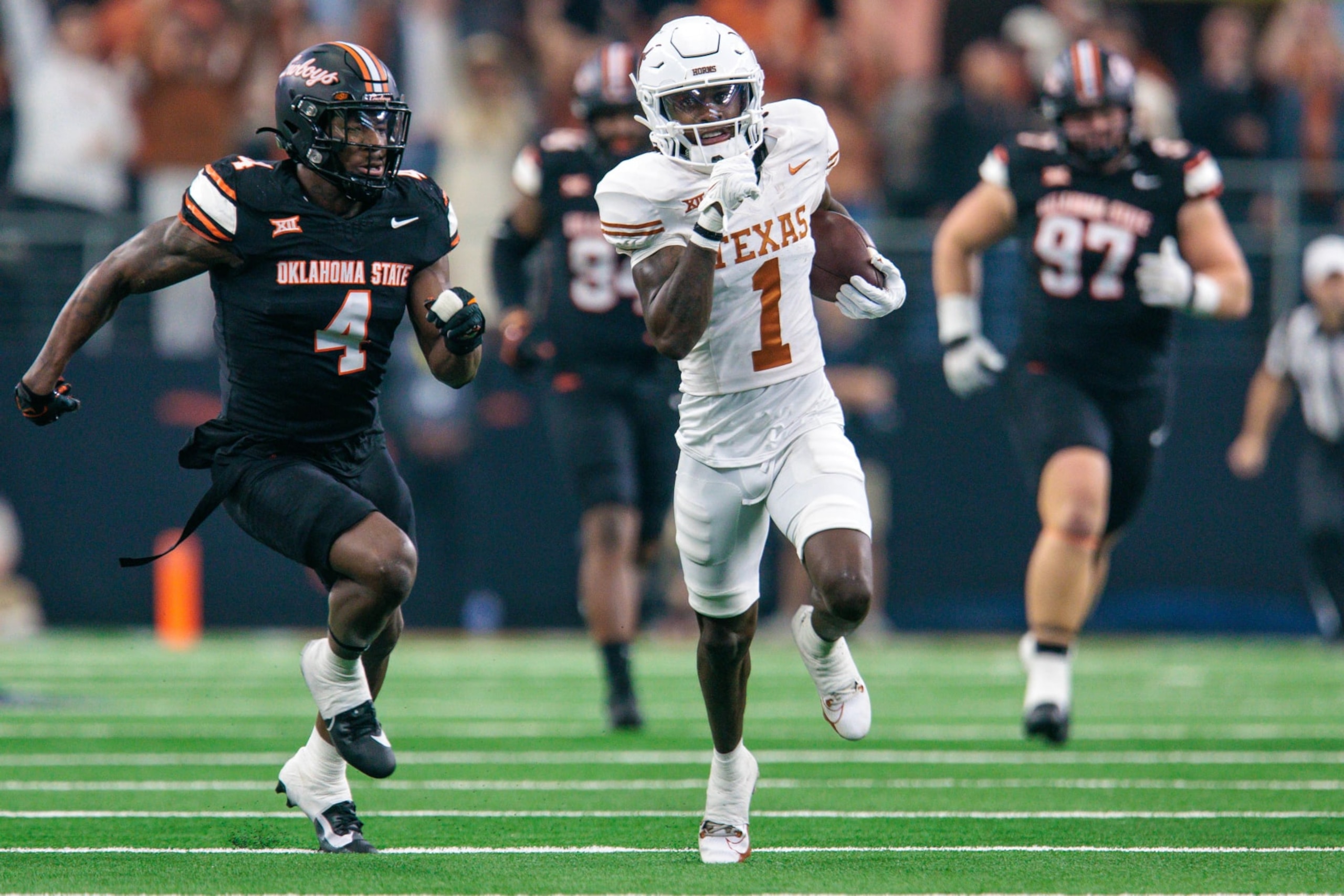 ARLINGTON, TX - DECEMBER 02: Texas Longhorns wide receiver Xavier Worthy (1) runs the ball by Oklahoma State Cowboys linebacker Nickolas Martin (4) at ATT Stadium in Arlington, Texas. (Photo by William Purnell/Icon Sportswire via Getty Images)