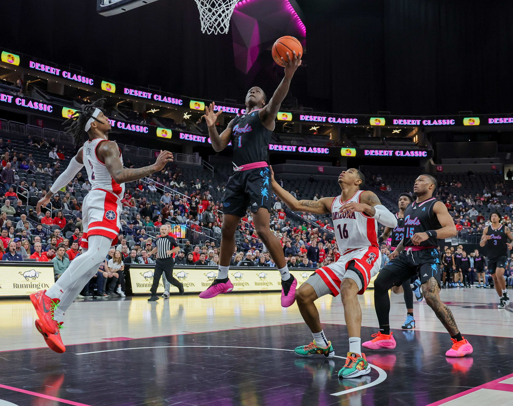 LAS VEGAS, NEVADA - DECEMBER 23: Johnell Davis #1 of the Florida Atlantic Owls shoots against Caleb Love #2 and Keshad Johnson #16 of the Arizona Wildcats in the first half of the Desert Classic at T-Mobile Arena on December 23, 2023 in Las Vegas, Nevada. (Photo by Ethan Miller/Getty Images)
