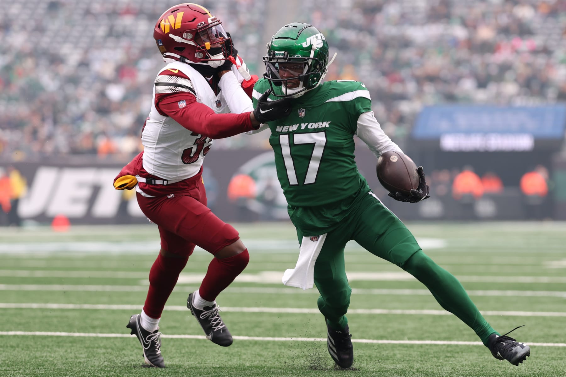 Jets WR Garrett Wilson  is pushed out of bounds by Commanders S Percy Butler