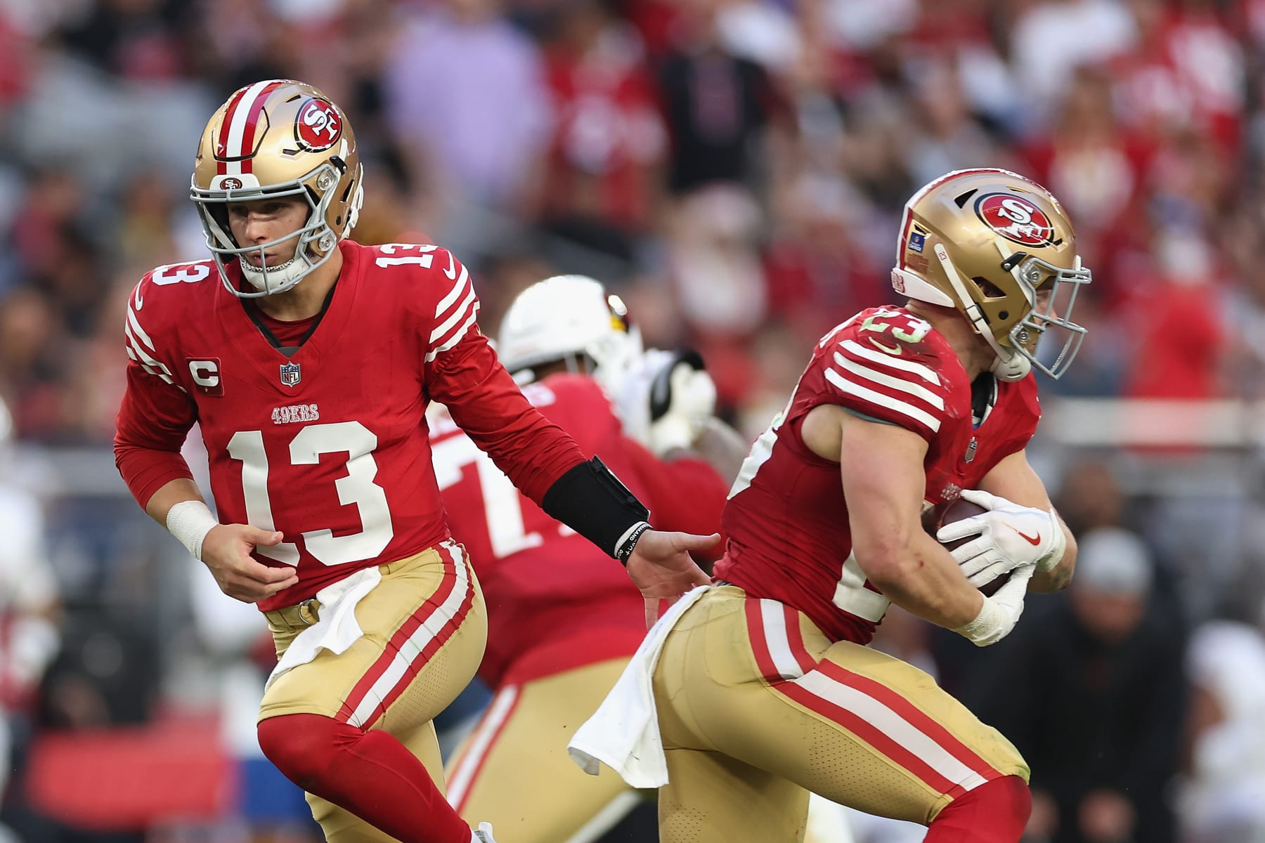 GLENDALE, ARIZONA - DECEMBER 17: Quarterback Brock Purdy #13 of the San Francisco 49ers hands the football to Christian McCaffrey #23 during the NFL game at State Farm Stadium on December 17, 2023 in Glendale, Arizona. The 49ers defeated the Cardinals 45-29.  (Photo by Christian Petersen/Getty Images)