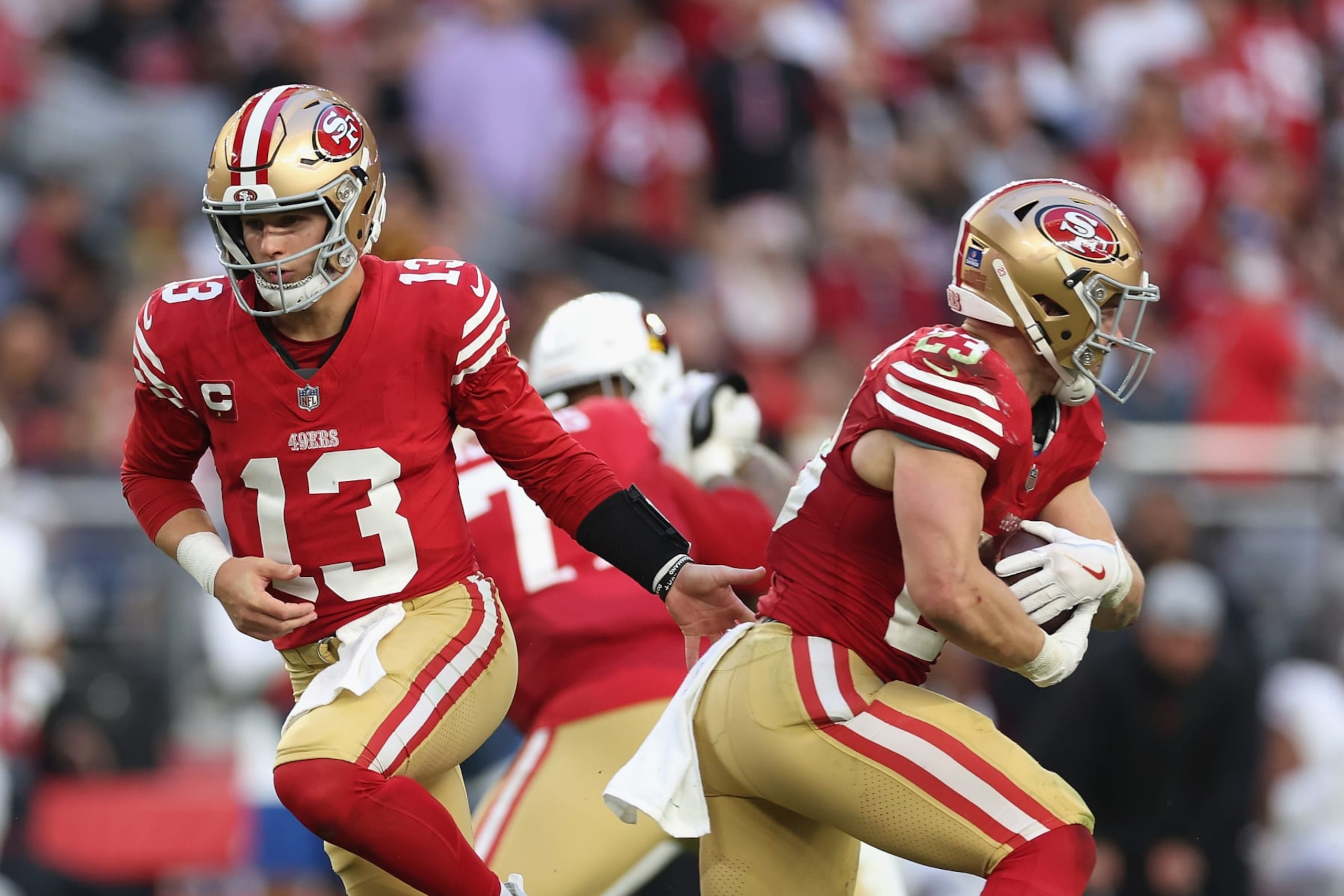 GLENDALE, ARIZONA - DECEMBER 17: Quarterback Brock Purdy #13 of the San Francisco 49ers hands the football to Christian McCaffrey #23 during the NFL game at State Farm Stadium on December 17, 2023 in Glendale, Arizona. The 49ers defeated the Cardinals 45-29.  (Photo by Christian Petersen/Getty Images)