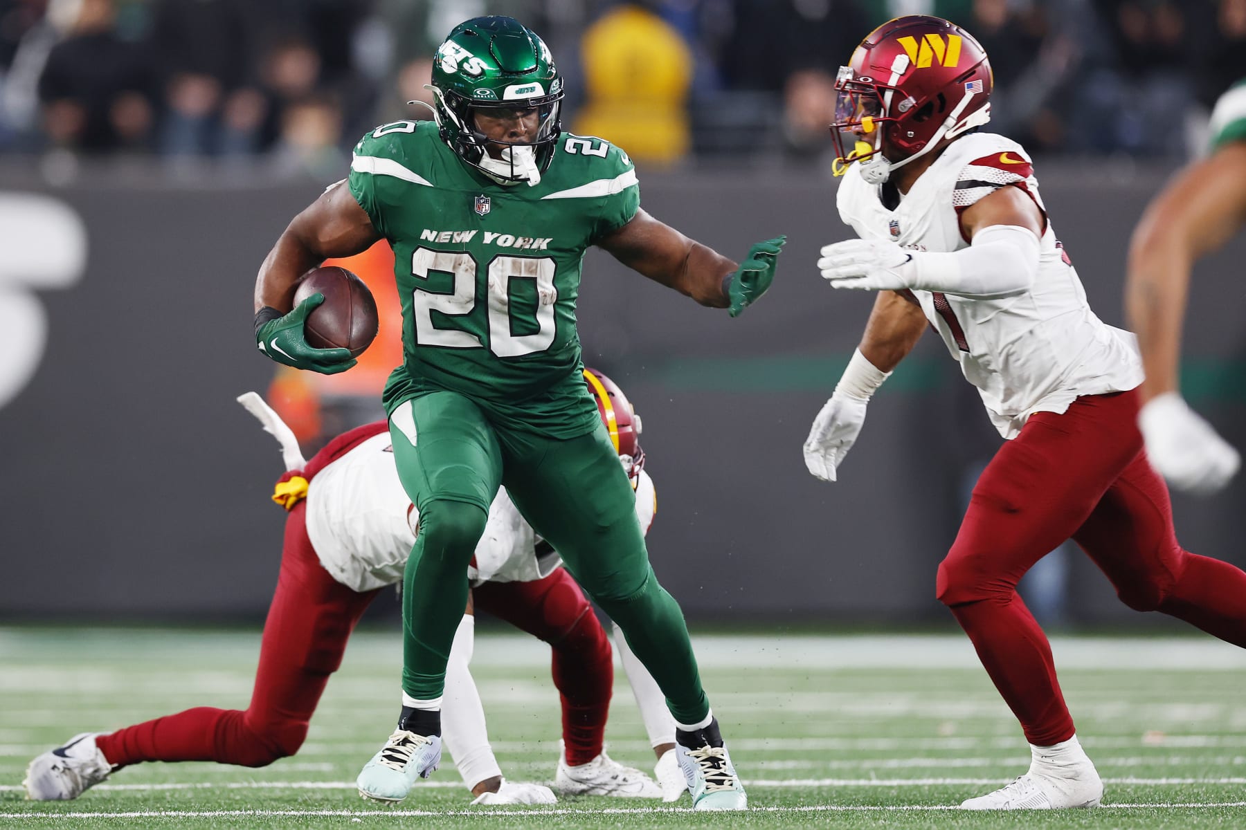 EAST RUTHERFORD, NEW JERSEY - DECEMBER 24: Breece Hall #20 of the New York Jets carries the ball during the second half as Kamren Curl #31 of the Washington Commanders is unable to make the tackle at MetLife Stadium on December 24, 2023 in East Rutherford, New Jersey. (Photo by Rich Schultz/Getty Images)