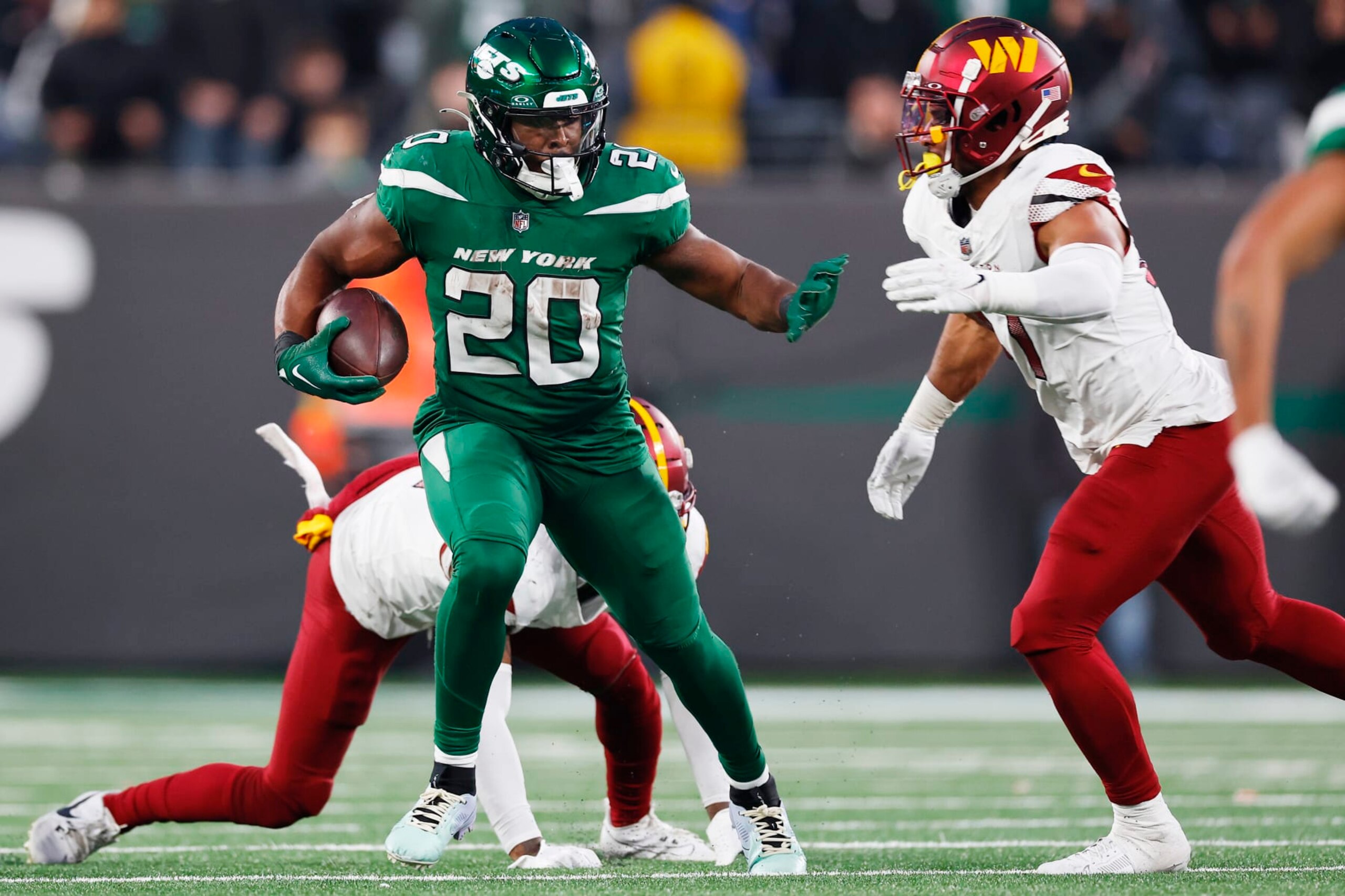 EAST RUTHERFORD, NEW JERSEY - DECEMBER 24: Breece Hall #20 of the New York Jets carries the ball during the second half as Kamren Curl #31 of the Washington Commanders is unable to make the tackle at MetLife Stadium on December 24, 2023 in East Rutherford, New Jersey. (Photo by Rich Schultz/Getty Images)