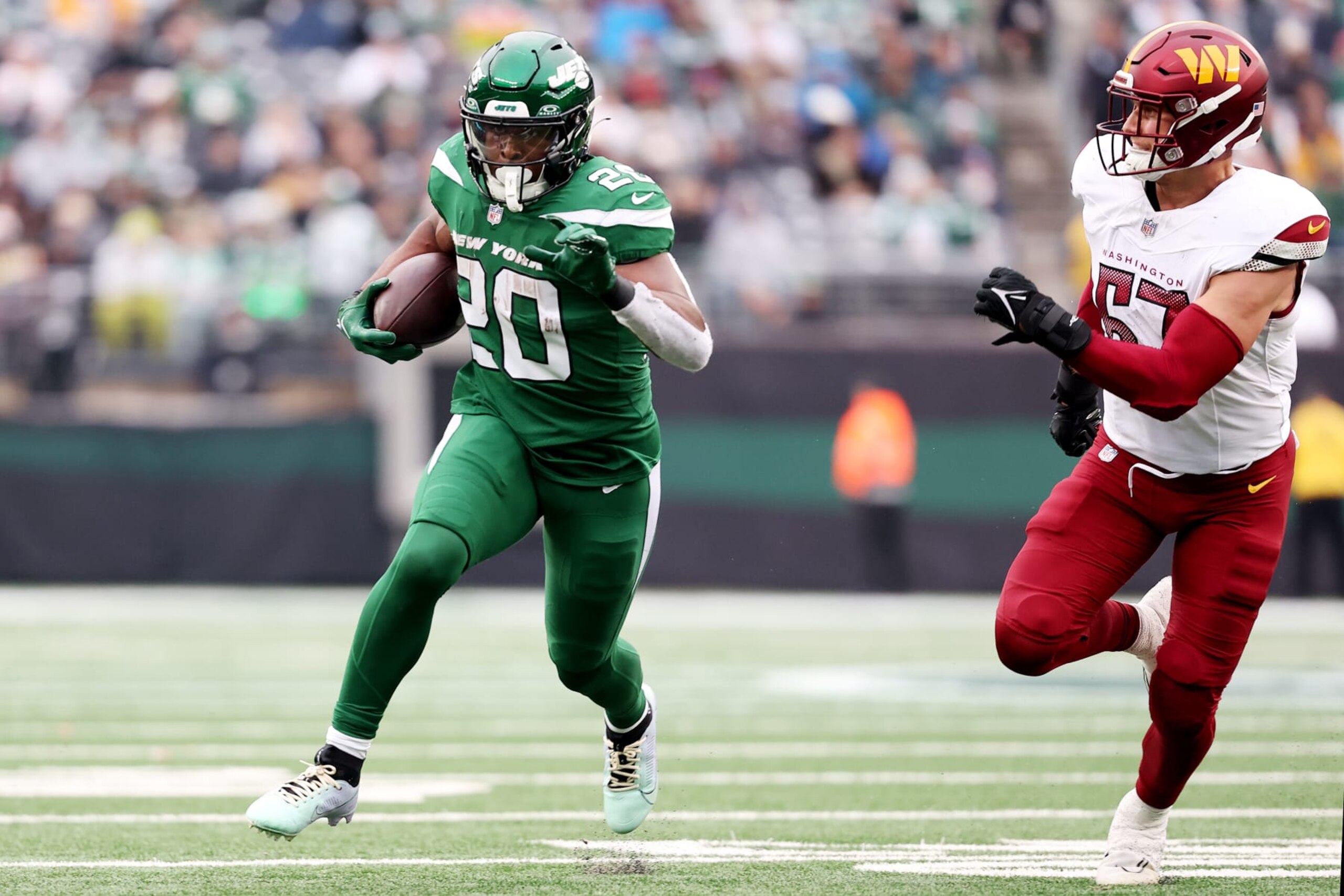 EAST RUTHERFORD, NEW JERSEY - DECEMBER 24: Breece Hall #20 of the New York Jets carries the ball during the first half against the Washington Commanders at MetLife Stadium on December 24, 2023 in East Rutherford, New Jersey. (Photo by Dustin Satloff/Getty Images)