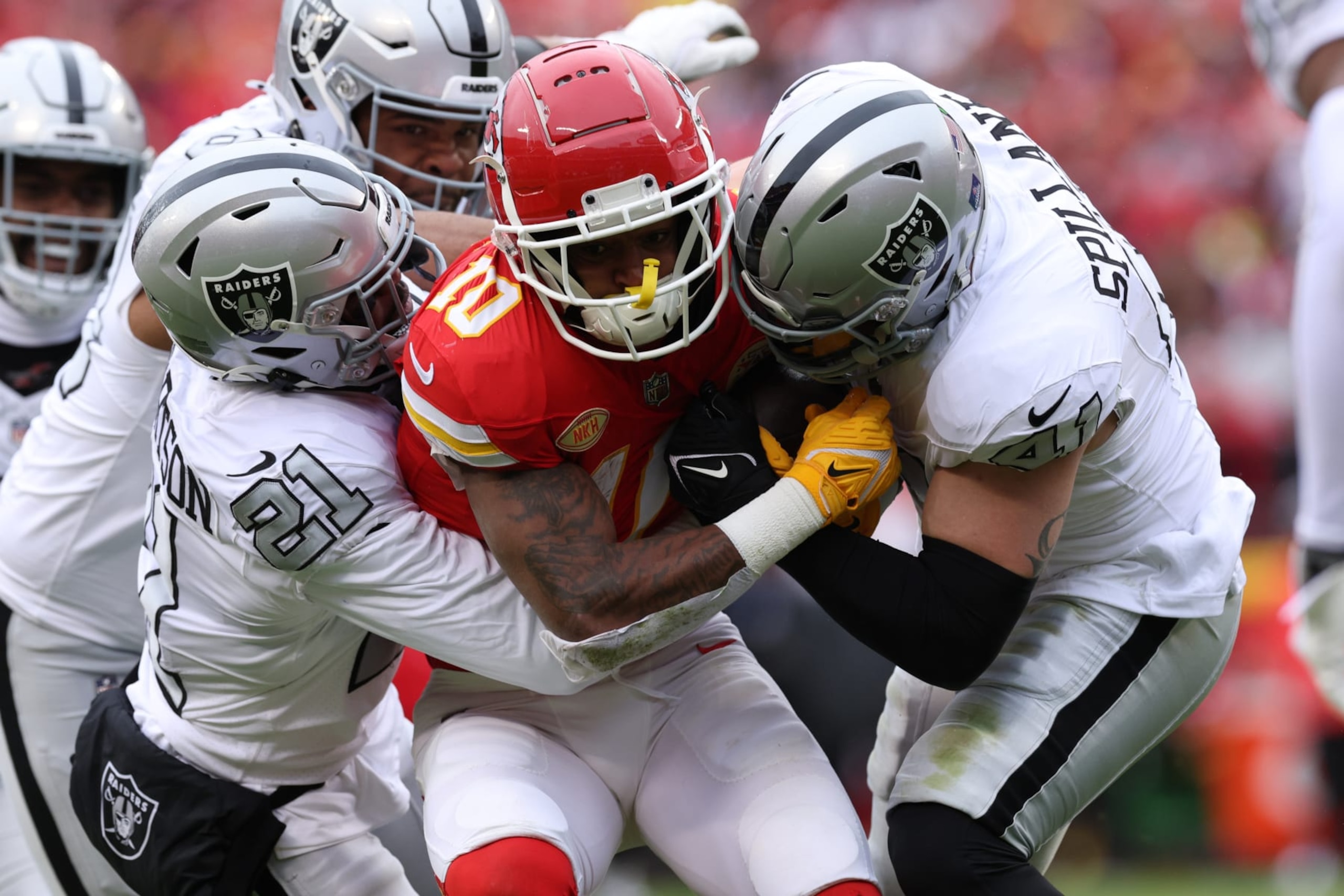 KANSAS CITY, MISSOURI - DECEMBER 25: Isiah Pacheco #10 of the Kansas City Chiefs is tackled by Amik Robertson #21 and Robert Spillane #41 of the Las Vegas Raiders during the first quarter at GEHA Field at Arrowhead Stadium on December 25, 2023 in Kansas City, Missouri. (Photo by Jamie Squire/Getty Images)