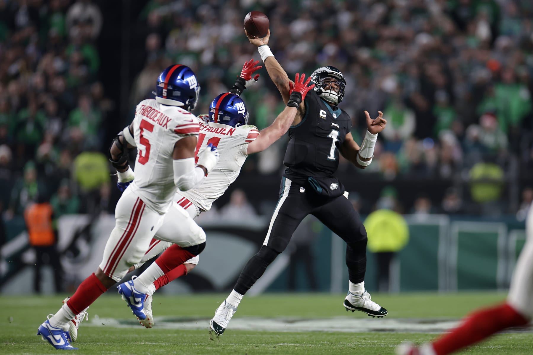 PHILADELPHIA, PENNSYLVANIA - DECEMBER 25: Jalen Hurts #1 of the Philadelphia Eagles passes the ball against Micah McFadden #41 of the New York Giants during the first quarter at Lincoln Financial Field on December 25, 2023 in Philadelphia, Pennsylvania. (Photo by Adam Hunger/Getty Images)
