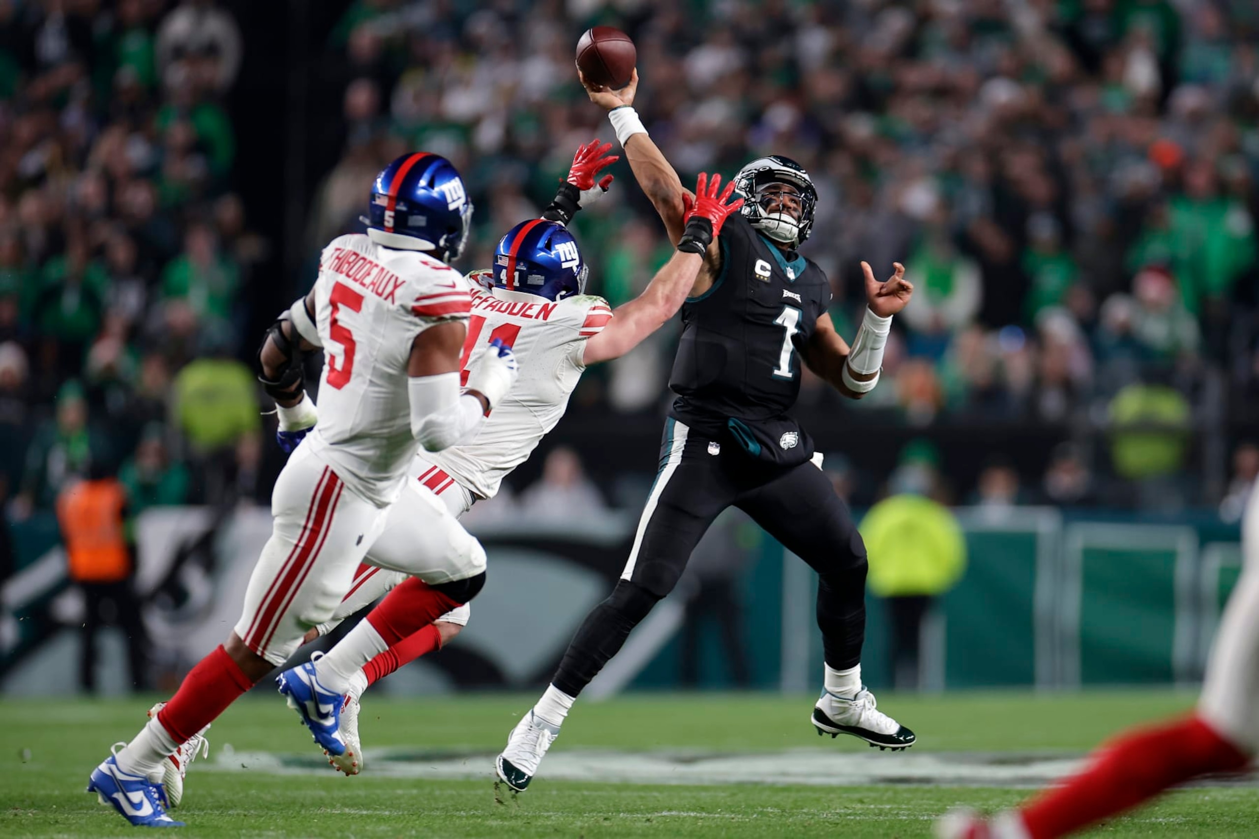 PHILADELPHIA, PENNSYLVANIA - DECEMBER 25: Jalen Hurts #1 of the Philadelphia Eagles passes the ball against Micah McFadden #41 of the New York Giants during the first quarter at Lincoln Financial Field on December 25, 2023 in Philadelphia, Pennsylvania. (Photo by Adam Hunger/Getty Images)