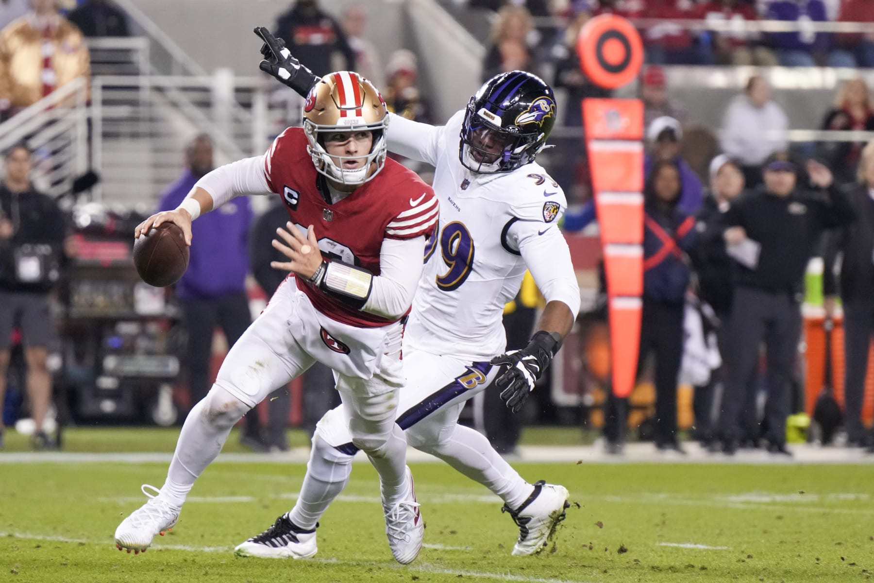 SANTA CLARA, CALIFORNIA - DECEMBER 25: Brock Purdy #13 of the San Francisco 49ers attempts a pass while pressured by Odafe Oweh #99 of the Baltimore Ravens during the second quarter at Levi's Stadium on December 25, 2023 in Santa Clara, California. (Photo by Loren Elliott/Getty Images)