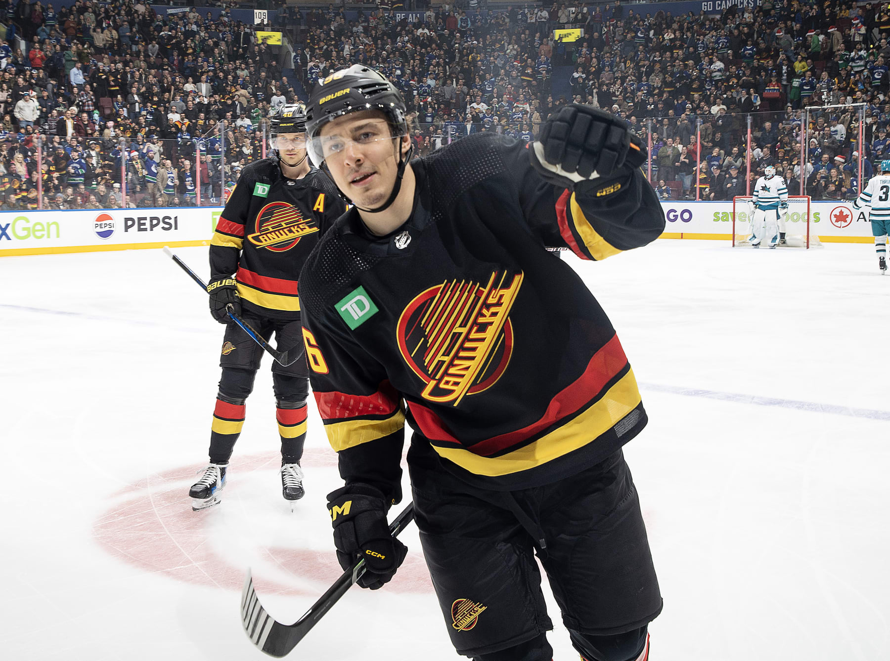 VANCOUVER, CANADA - DECEMBER 23: Andrei Kuzmenko #96 of the Vancouver Canucks skates back to the bench to celebrate his goal with teammates during the first period of their NHL game against the San Jose Sharks at Rogers Arena on December 23, 2023 in Vancouver, British Columbia, Canada.  (Photo by Jeff Vinnick/NHLI via Getty Images)