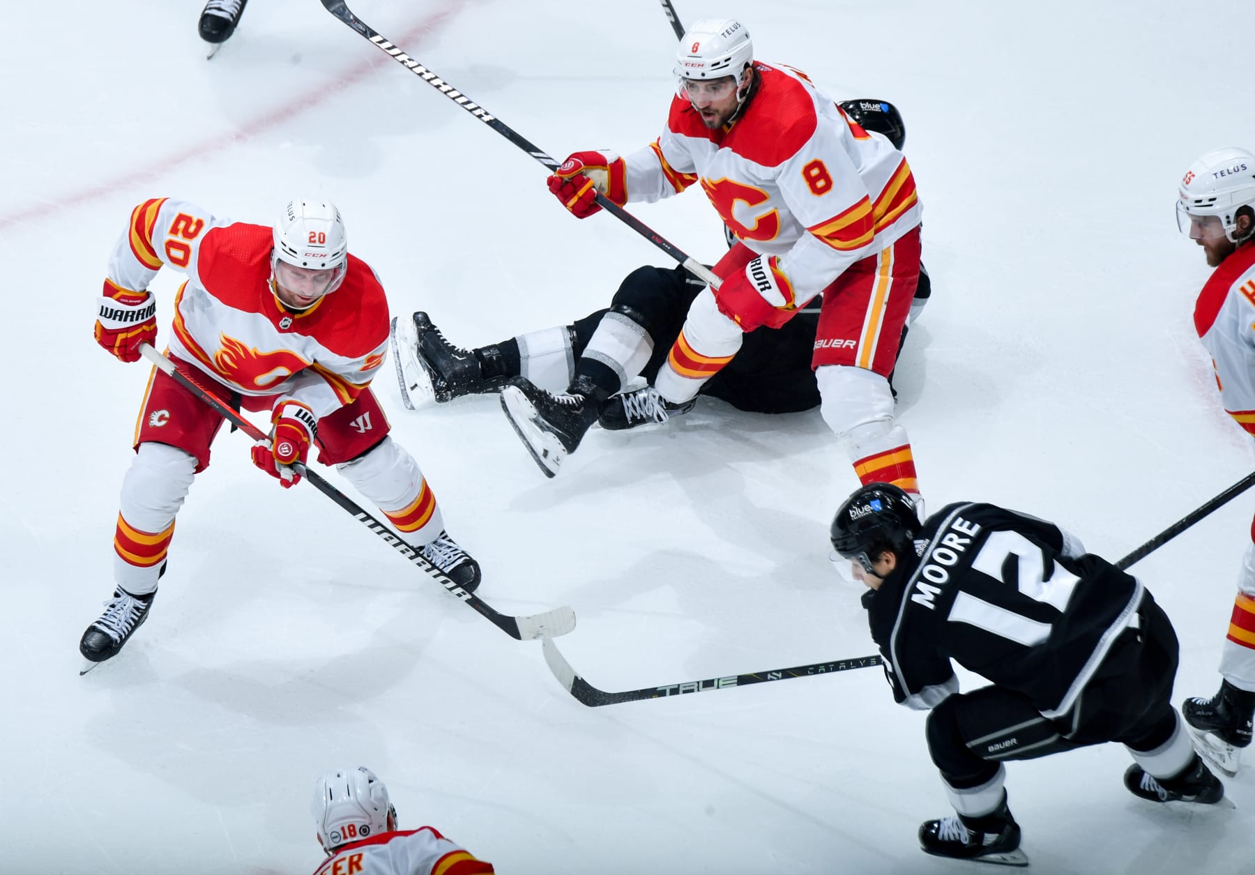 LOS ANGELES, CA - DECEMBER 23: Blake Coleman #20 of the Calgary Flames, Trevor Moore #12 of the Los Angeles Kings and Chris Tanev #8 of the Calgary Flames battle for position during the second period at Crypto.com Arena on December 23, 2023 in Los Angeles, California. (Photo by Juan Ocampo/NHLI via Getty Images)