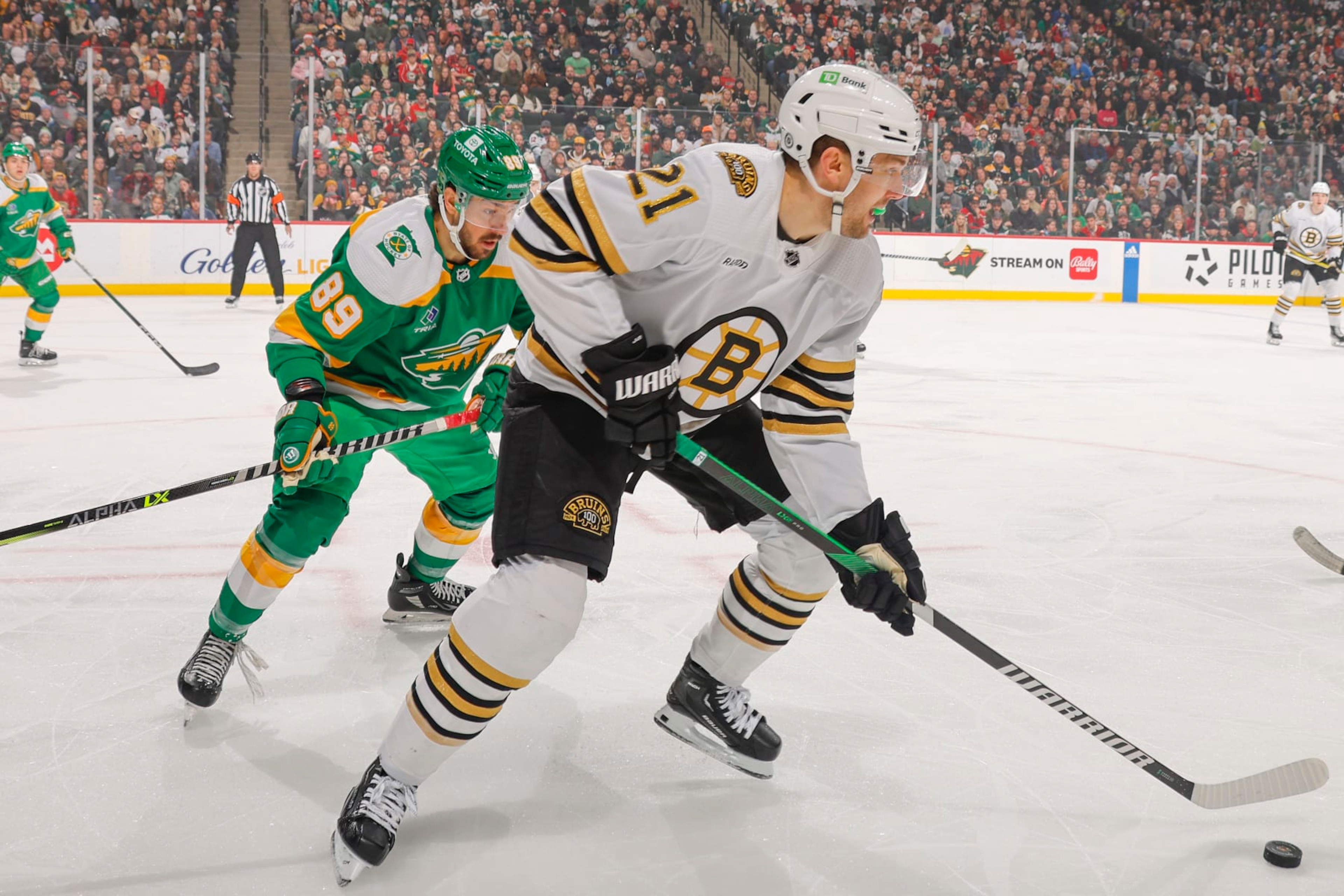 SAINT PAUL, MN - DECEMBER 23: James van Riemsdyk #21 of the Boston Bruins skates with the puck while Frederick Gaudreau #89 of the Minnesota Wild defends during the game at the Xcel Energy Center on December 23, 2023 in Saint Paul, Minnesota. (Photo by Bruce Kluckhohn/NHLI via Getty Images) SAINT PAUL, MN - DECEMBER 23: James van Riemsdyk #21 of the Boston Bruins skates with the puck while Frederick Gaudreau #89 of the Minnesota Wild defends during the game at the Xcel Energy Center on December 23, 2023 in Saint Paul, Minnesota. (Photo by Bruce Kluckhohn/NHLI via Getty Images)