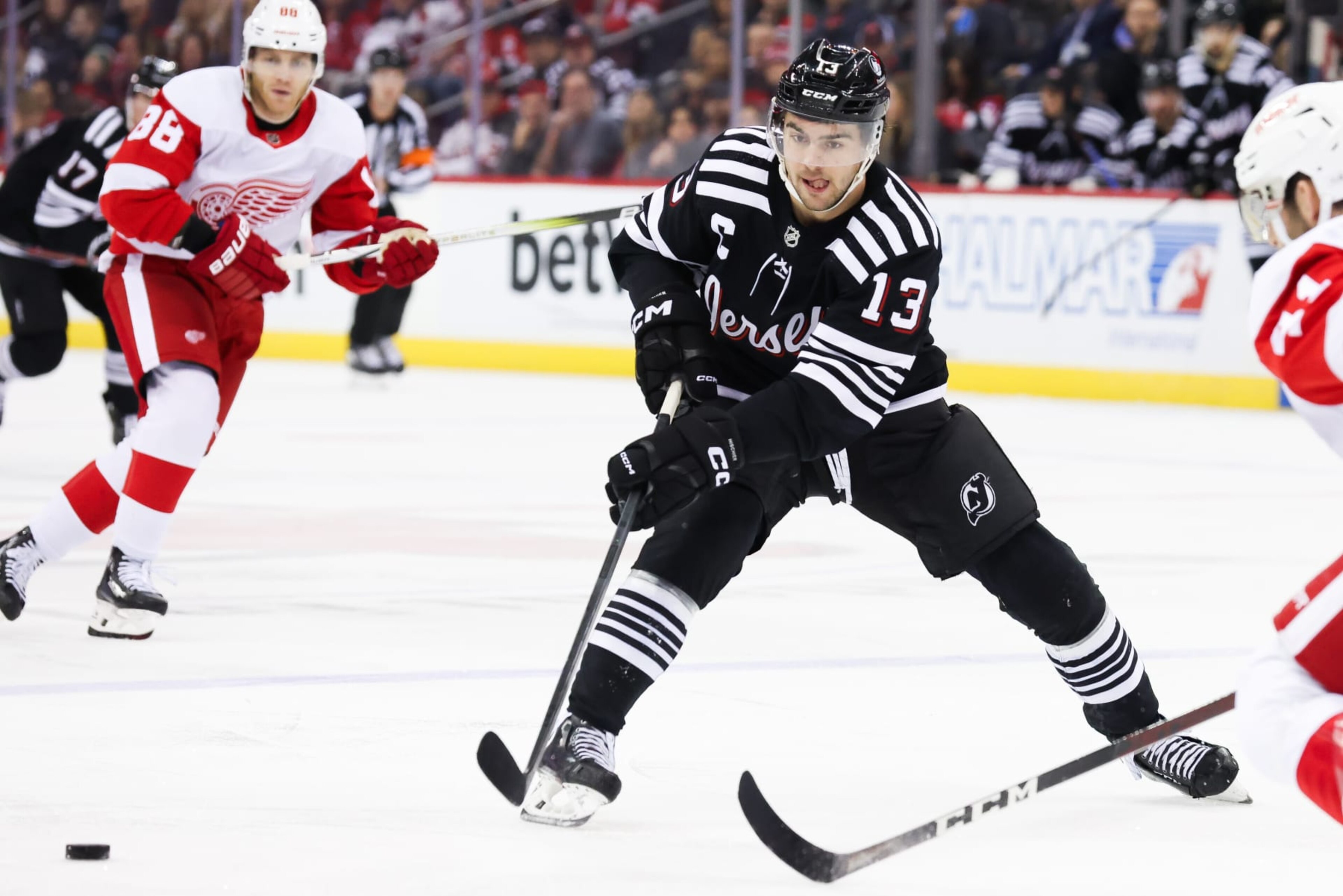 NEWARK, NJ - DECEMBER 23: New Jersey Devils center Nico Hischier (13) passes the puck during a game between the Detroit Red Wings and New Jersey Devils on December 23, 2023 at Prudential Center in the Newark, New Jersey. (Photo by Andrew Mordzynski/Icon Sportswire via Getty Images) NEWARK, NJ - DECEMBER 23: New Jersey Devils center Nico Hischier (13) passes the puck during a game between the Detroit Red Wings and New Jersey Devils on December 23, 2023 at Prudential Center in the Newark, New Jersey. (Photo by Andrew Mordzynski/Icon Sportswire via Getty Images)