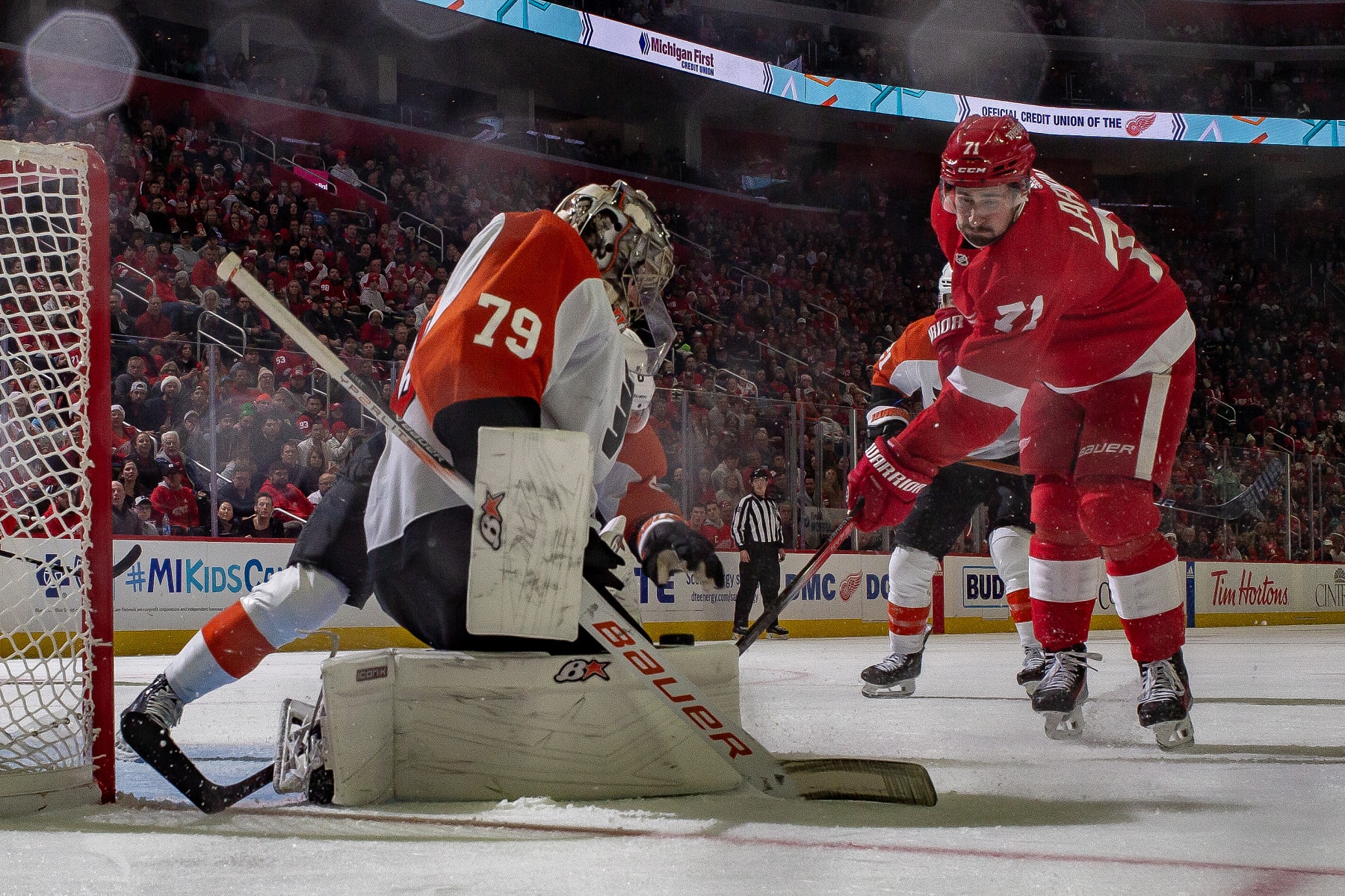 DETROIT, MI - DECEMBER 22: Carter Hart #79 of the Philadelphia Flyers makes a save as Dylan Larkin #71 of the Detroit Red Wings looks for the rebound during the second period at Little Caesars Arena on December 22, 2023 in Detroit, Michigan. Detroit defeated Philadelphia 7-6 in O.T.. (Photo by Dave Reginek/NHLI via Getty Images)