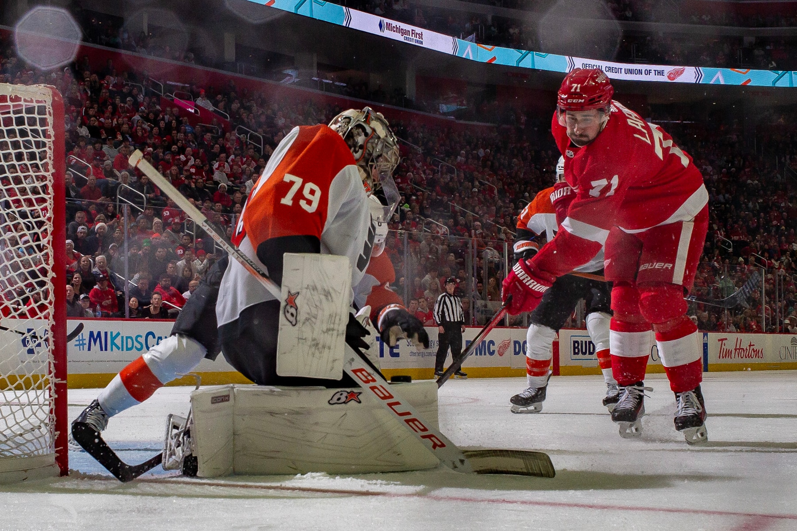DETROIT, MI - DECEMBER 22: Carter Hart #79 of the Philadelphia Flyers makes a save as Dylan Larkin #71 of the Detroit Red Wings looks for the rebound during the second period at Little Caesars Arena on December 22, 2023 in Detroit, Michigan. Detroit defeated Philadelphia 7-6 in O.T.. (Photo by Dave Reginek/NHLI via Getty Images)