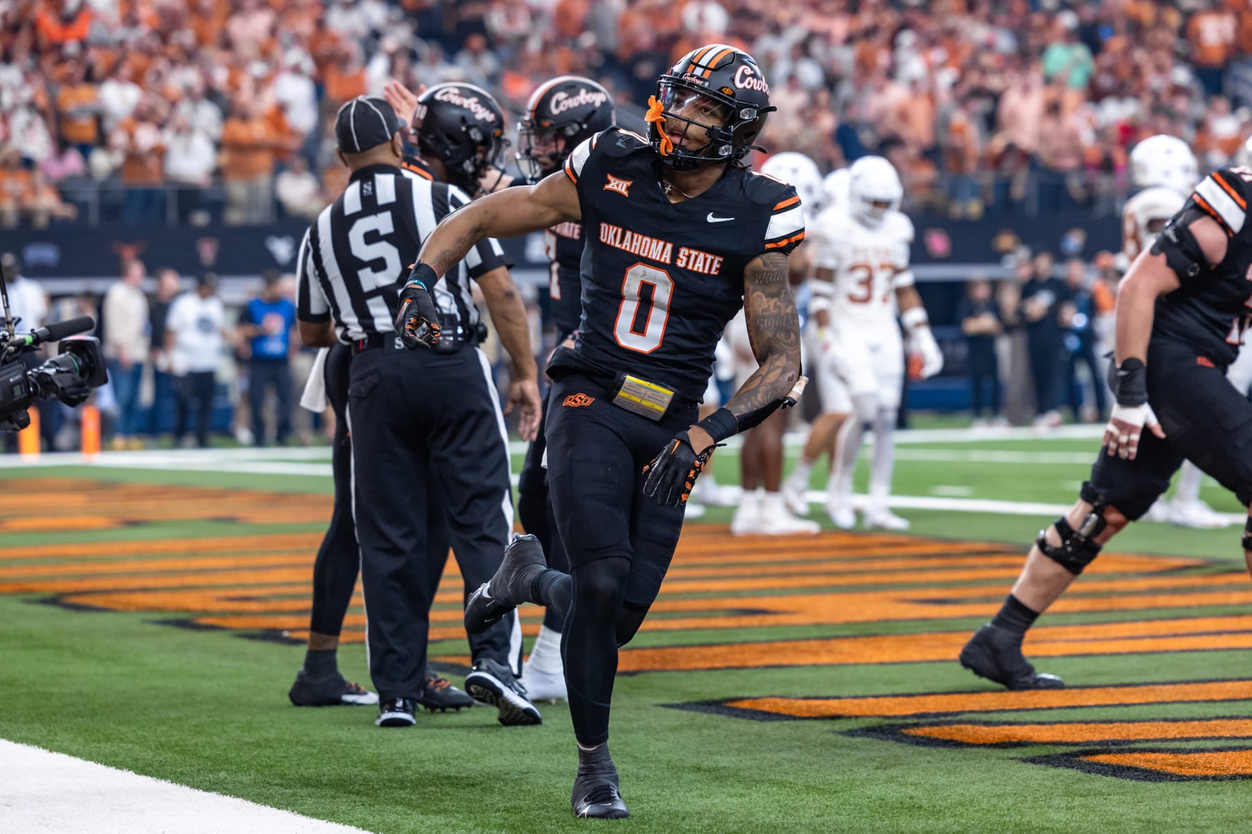 ARLINGTON, TX - DECEMBER 02: Oklahoma State Cowboys running back Ollie Gordon II (#0) runs off the field after a score during the Big 12 Championship football game between the Texas Longhorns and Oklahoma State Cowboys on December 02, 2023 at AT&T Studium in Arlington, Texas. (Photo by Matthew Visinsky/Icon Sportswire via Getty Images)