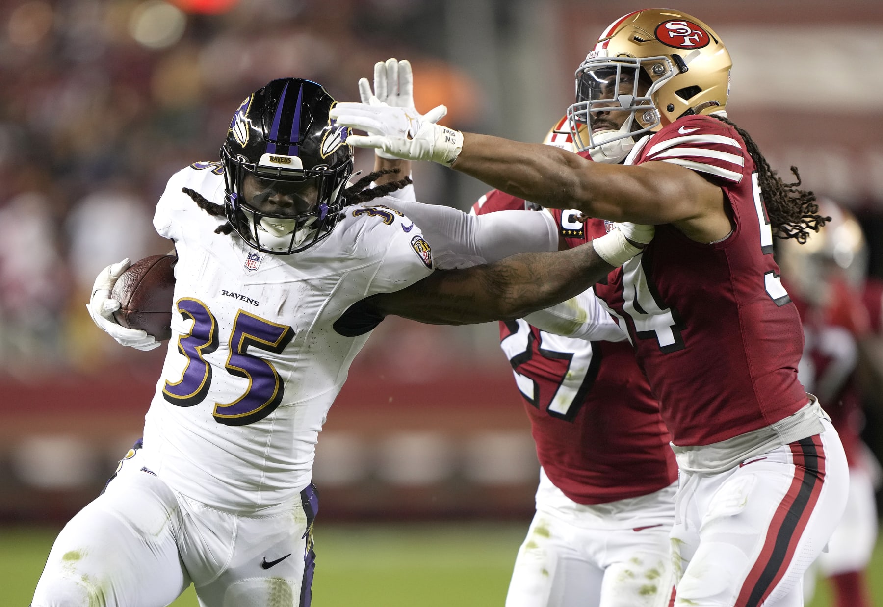 SANTA CLARA, CALIFORNIA - DECEMBER 25: Gus Edwards #35 of the Baltimore Ravens stiff arms Fred Warner #54 of the San Francisco 49ers during the third quarter at Levi's Stadium on December 25, 2023 in Santa Clara, California. (Photo by Thearon W. Henderson/Getty Images)