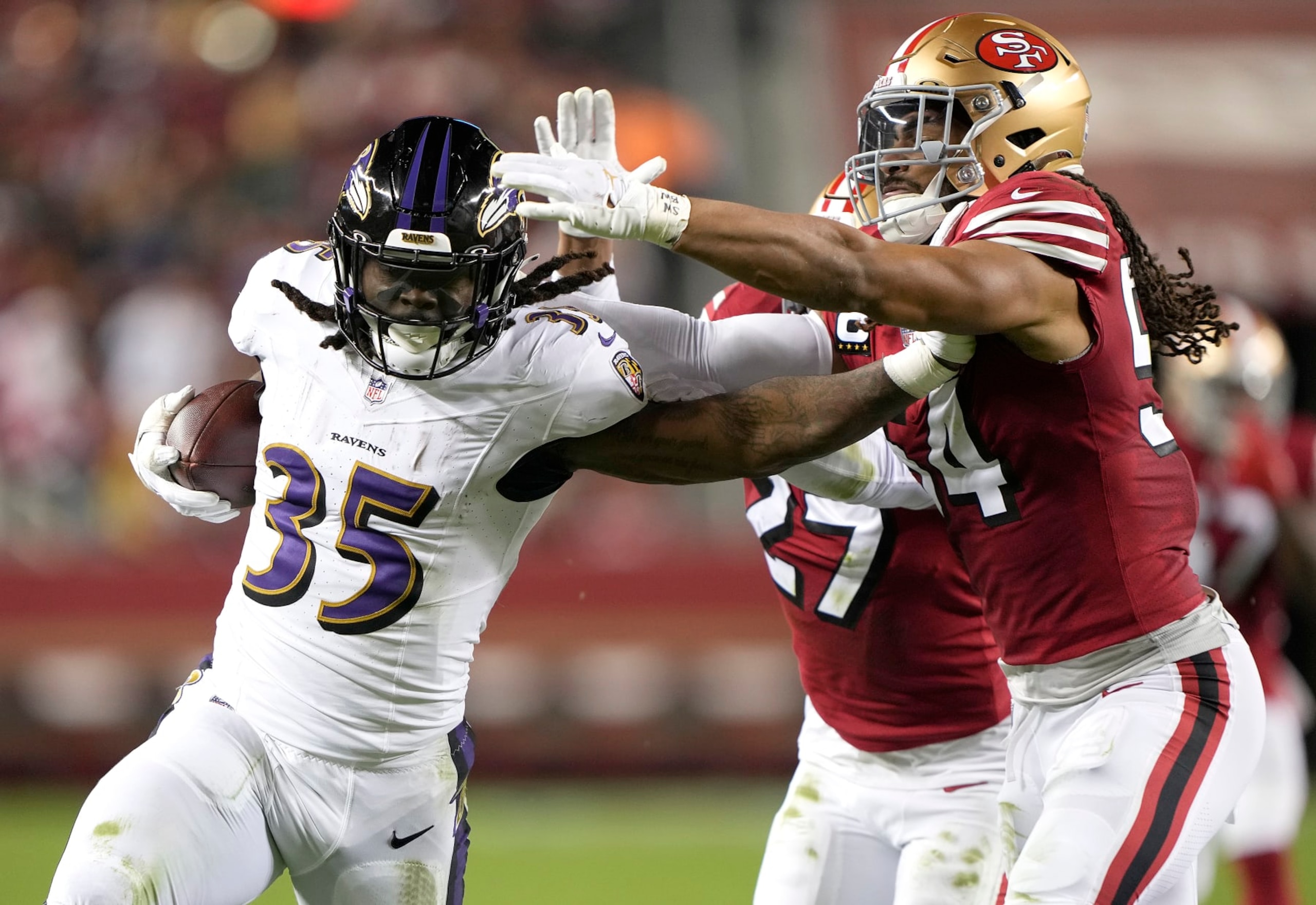SANTA CLARA, CALIFORNIA - DECEMBER 25: Gus Edwards #35 of the Baltimore Ravens stiff arms Fred Warner #54 of the San Francisco 49ers during the third quarter at Levi's Stadium on December 25, 2023 in Santa Clara, California. (Photo by Thearon W. Henderson/Getty Images)
