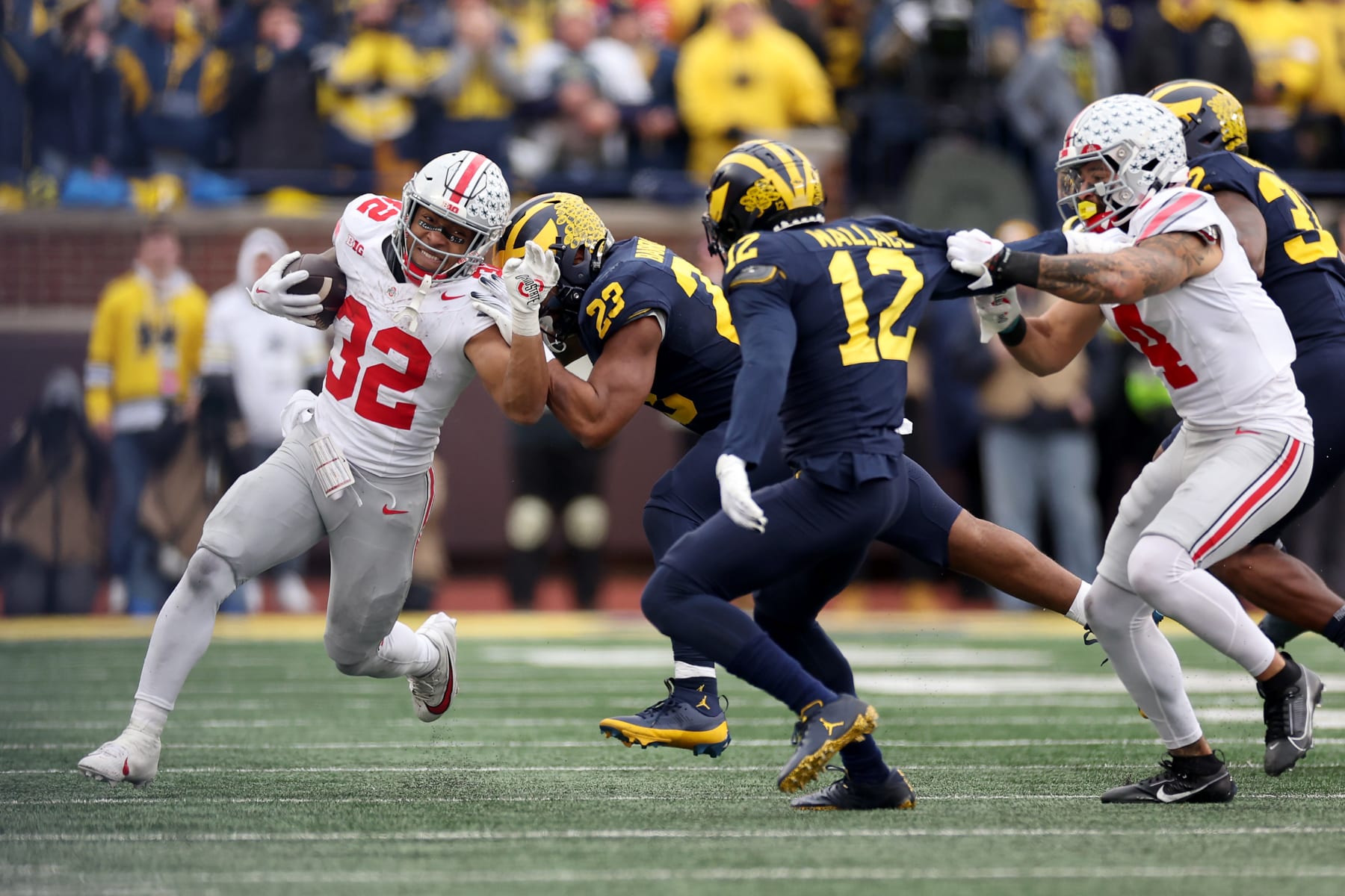 ANN ARBOR, MICHIGAN - NOVEMBER 25: TreVeyon Henderson #32 of the Ohio State Buckeyes runs the ball against Michael Barrett #23 of the Michigan Wolverines during the fourth quarter in the game at Michigan Stadium on November 25, 2023 in Ann Arbor, Michigan. (Photo by Ezra Shaw/Getty Images)