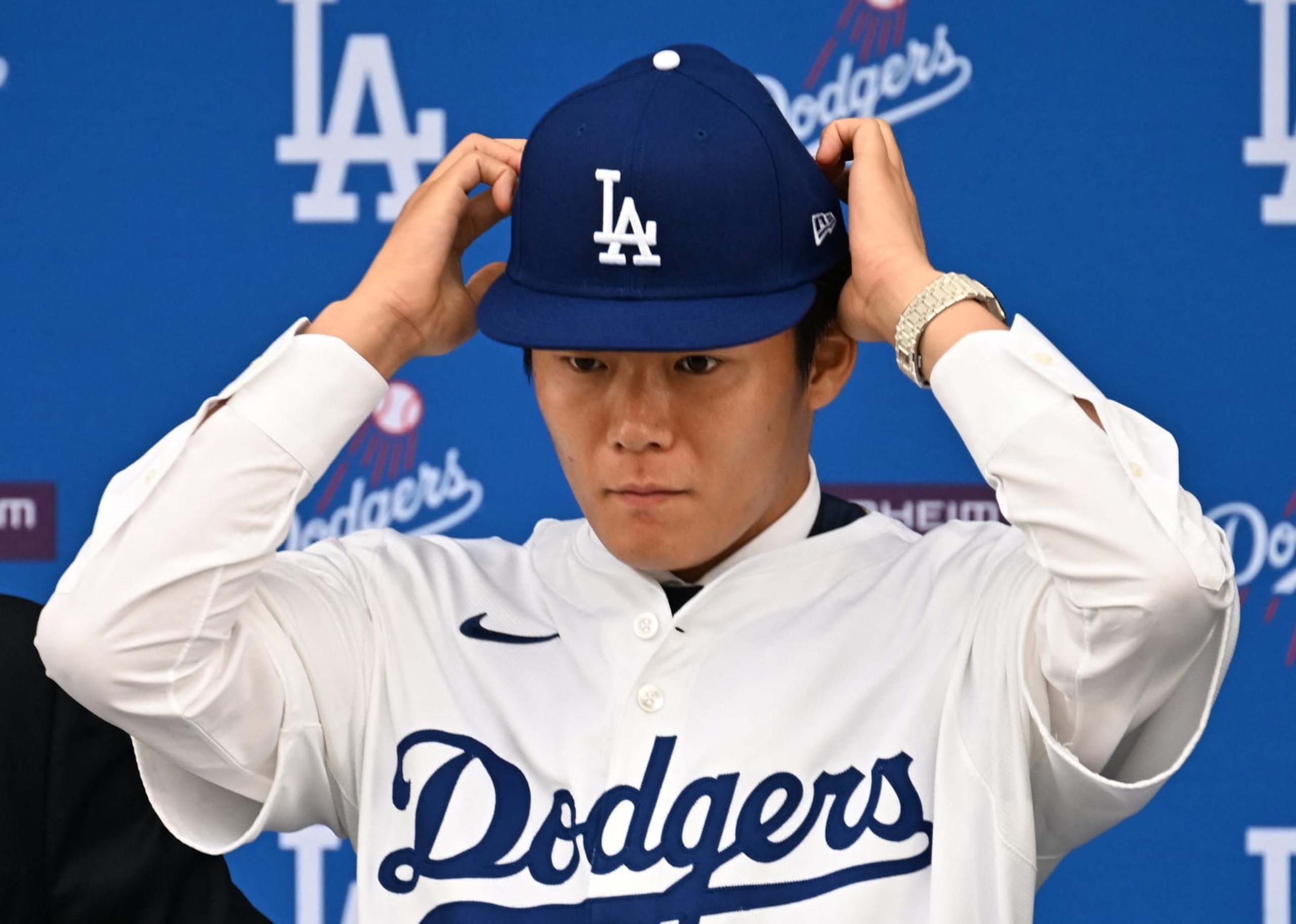 New Los Angeles Dodger, Japanese pitcher Yoshinobu Yamamoto, adjusts his hat during his introductory press conference after signing with the Los Angeles Dodgers at Dodgers Stadium in Los Angeles on December 27, 2023. The Los Angeles Dodgers confirmed their signing of Japanese pitcher Yoshinobu Yamamoto on December 27, formally introducing him a week after reports he had agreed to a 12-year, $325 million deal with the club.
Yamamoto's arrival comes two weeks after the Dodgers inked two-way superstar Shohei Ohtani to a 10-year, $700 million deal. (Photo by Robyn BECK / AFP) (Photo by ROBYN BECK/AFP via Getty Images) New Los Angeles Dodger, Japanese pitcher Yoshinobu Yamamoto, adjusts his hat during his introductory press conference after signing with the Los Angeles Dodgers at Dodgers Stadium in Los Angeles on December 27, 2023. The Los Angeles Dodgers confirmed their signing of Japanese pitcher Yoshinobu Yamamoto on December 27, formally introducing him a week after reports he had agreed to a 12-year, $325 million deal with the club.
Yamamoto's arrival comes two weeks after the Dodgers inked two-way superstar Shohei Ohtani to a 10-year, $700 million deal. (Photo by Robyn BECK / AFP) (Photo by ROBYN BECK/AFP via Getty Images)