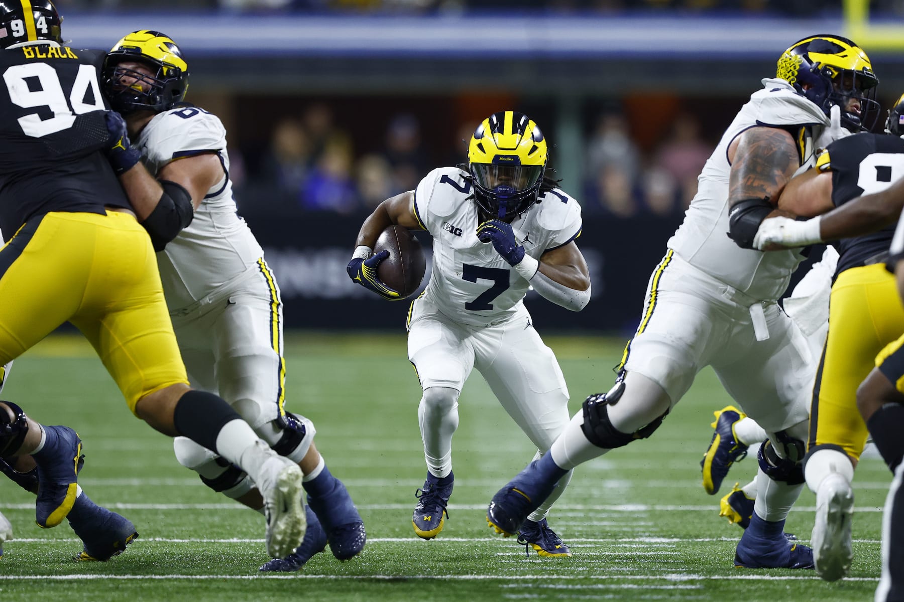 INDIANAPOLIS, IN - DECEMBER 02: Michigan Wolverines running back Donovan Edwards (7) hits the hole as he goes up field during the Big Ten Championship Game between the Michigan Wolverines and the Iowa Hawkeyes on December 02, 2023 at Lucas Oil Stadium in Indianapolis,IN.  (Photo by Jeffrey Brown/Icon Sportswire via Getty Images)