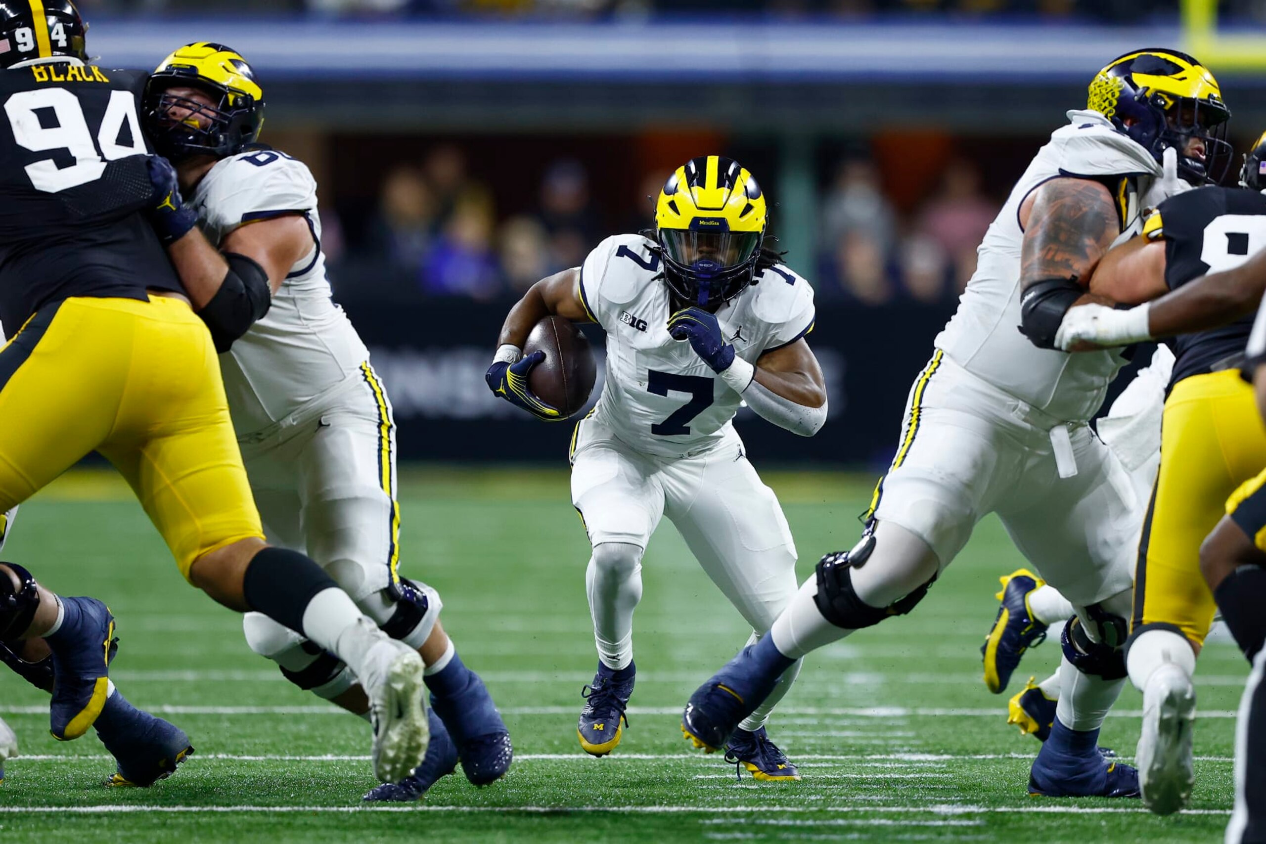 INDIANAPOLIS, IN - DECEMBER 02: Michigan Wolverines running back Donovan Edwards (7) hits the hole as he goes up field during the Big Ten Championship Game between the Michigan Wolverines and the Iowa Hawkeyes on December 02, 2023 at Lucas Oil Stadium in Indianapolis,IN.  (Photo by Jeffrey Brown/Icon Sportswire via Getty Images)