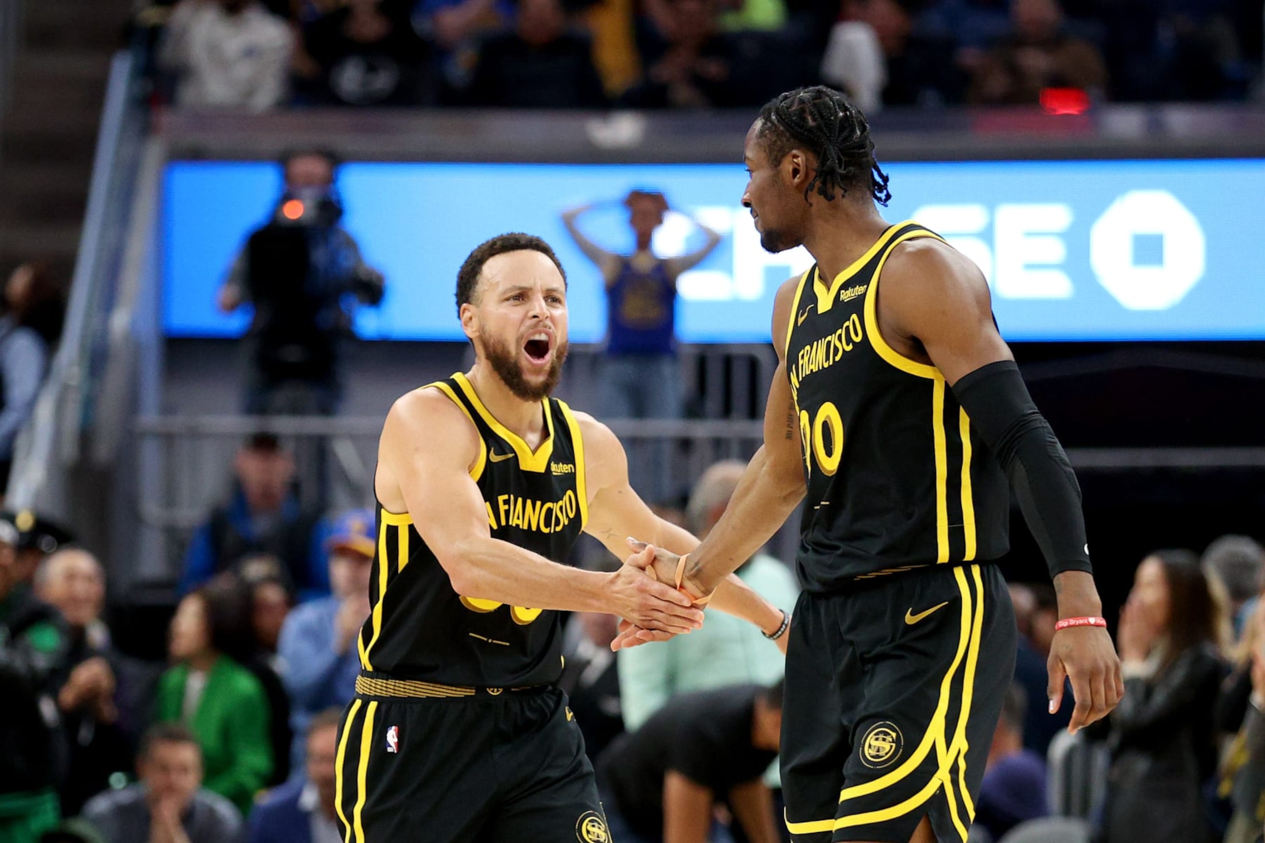 SAN FRANCISCO, CALIFORNIA - DECEMBER 19: Stephen Curry #30 congratulates Jonathan Kuminga #00 of the Golden State Warriors during their game against the Boston Celtics at Chase Center on December 19, 2023 in San Francisco, California. NOTE TO USER: User expressly acknowledges and agrees that, by downloading and or using this photograph, User is consenting to the terms and conditions of the Getty Images License Agreement.  (Photo by Ezra Shaw/Getty Images)