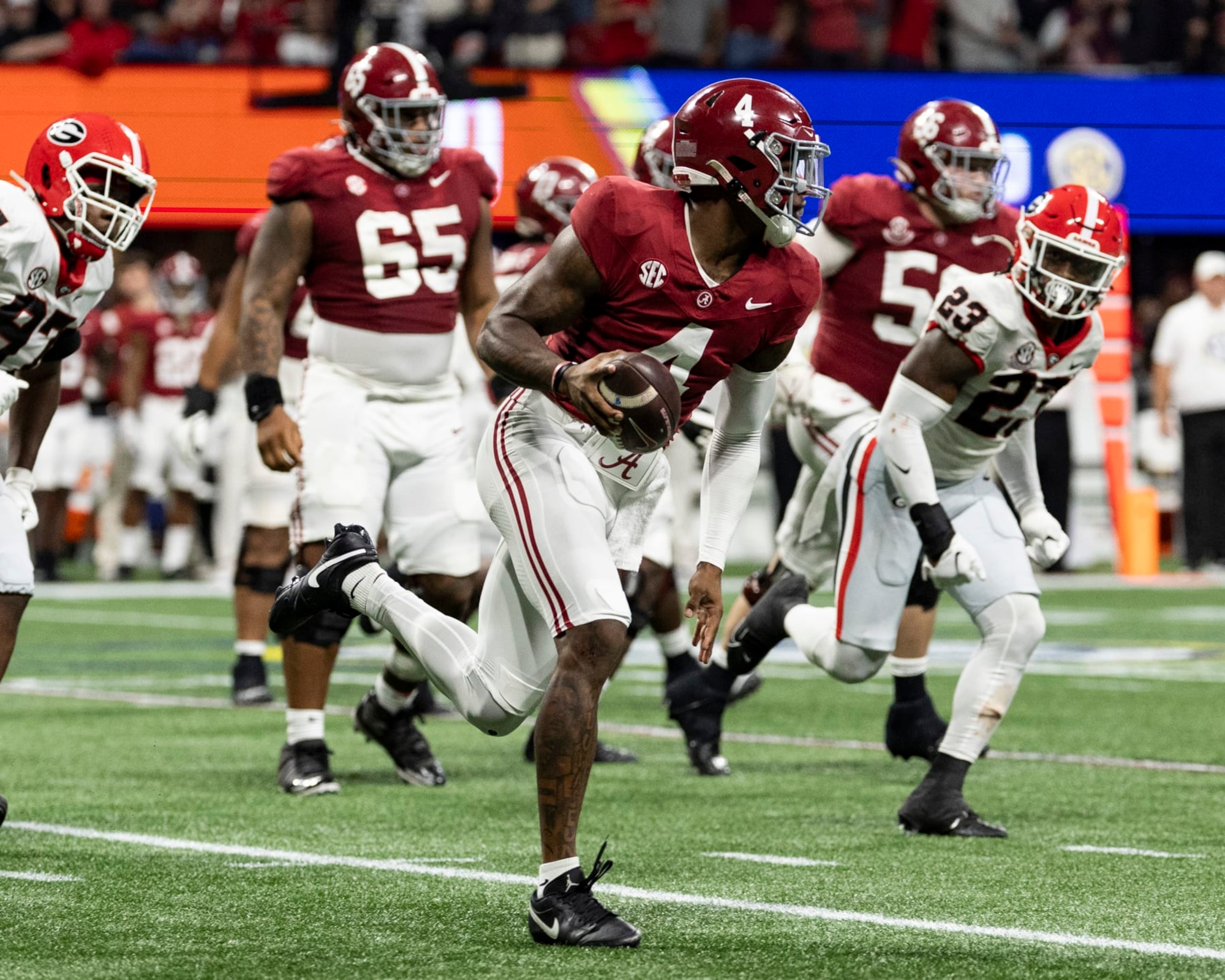 ATLANTA, GEORGIA - DECEMBER 2: Jalen Milroe #4 of the Alabama Crimson Tide avoids the Georgia pass rush during a game between University of Georgia and University of Alabama at Mercedes-Benz Stadium on December 2, 2023 in Atlanta, Georgia. (Photo by Steve Limentani/ISI Photos/Getty Images)