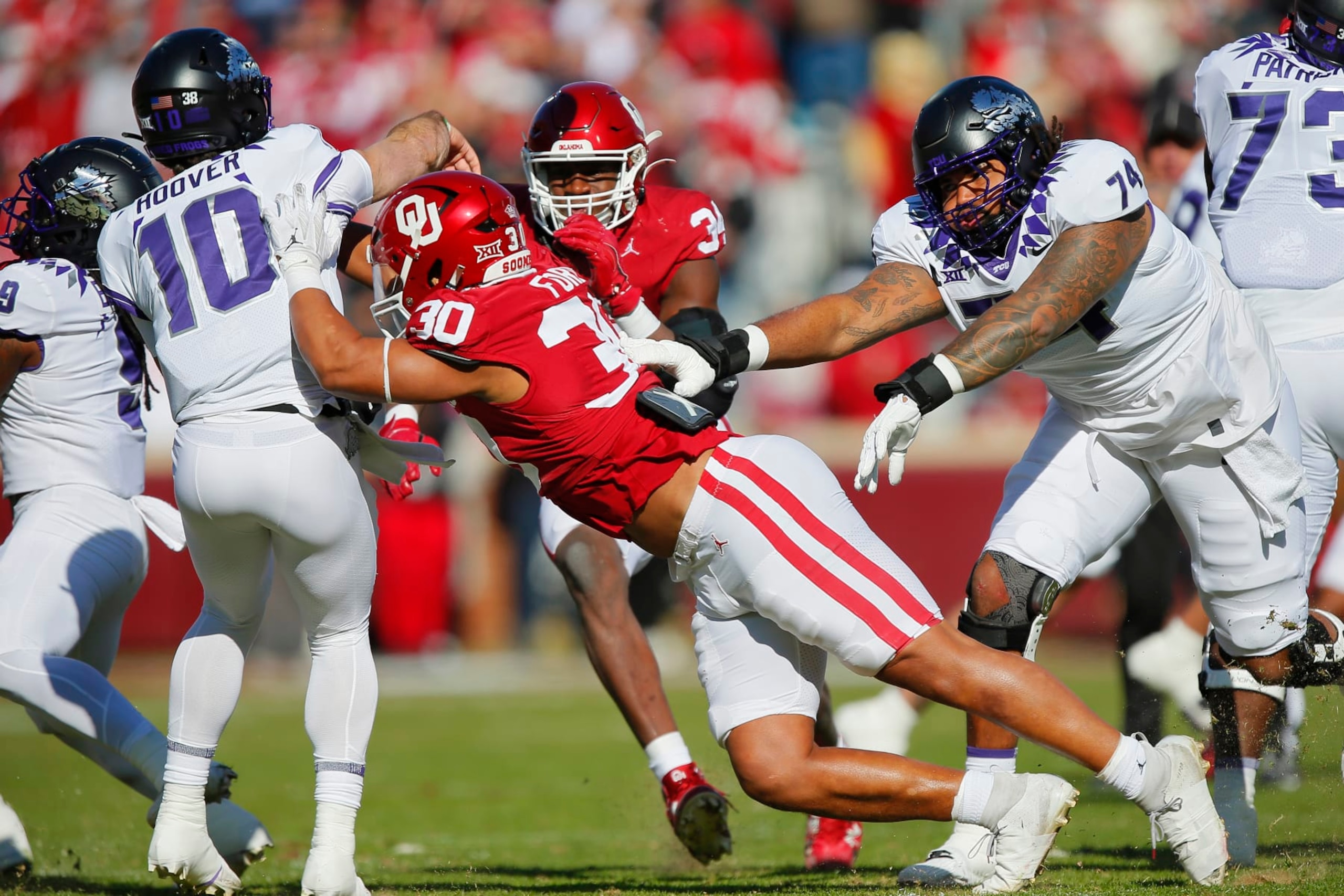 NORMAN, OKLAHOMA - NOVEMBER 24:  Defensive lineman Trace Ford #30 and defensive lineman Adepoju Adebawore #34 of the Oklahoma Sooners rush quarterback Josh Hoover #10 of the TCU Horned Frogs for an incomplete pass early in the first quarter at Gaylord Family Oklahoma Memorial Stadium on November 24, 2023 in Norman, Oklahoma.  Oklahoma won 69-45.  (Photo by Brian Bahr/Getty Images)
