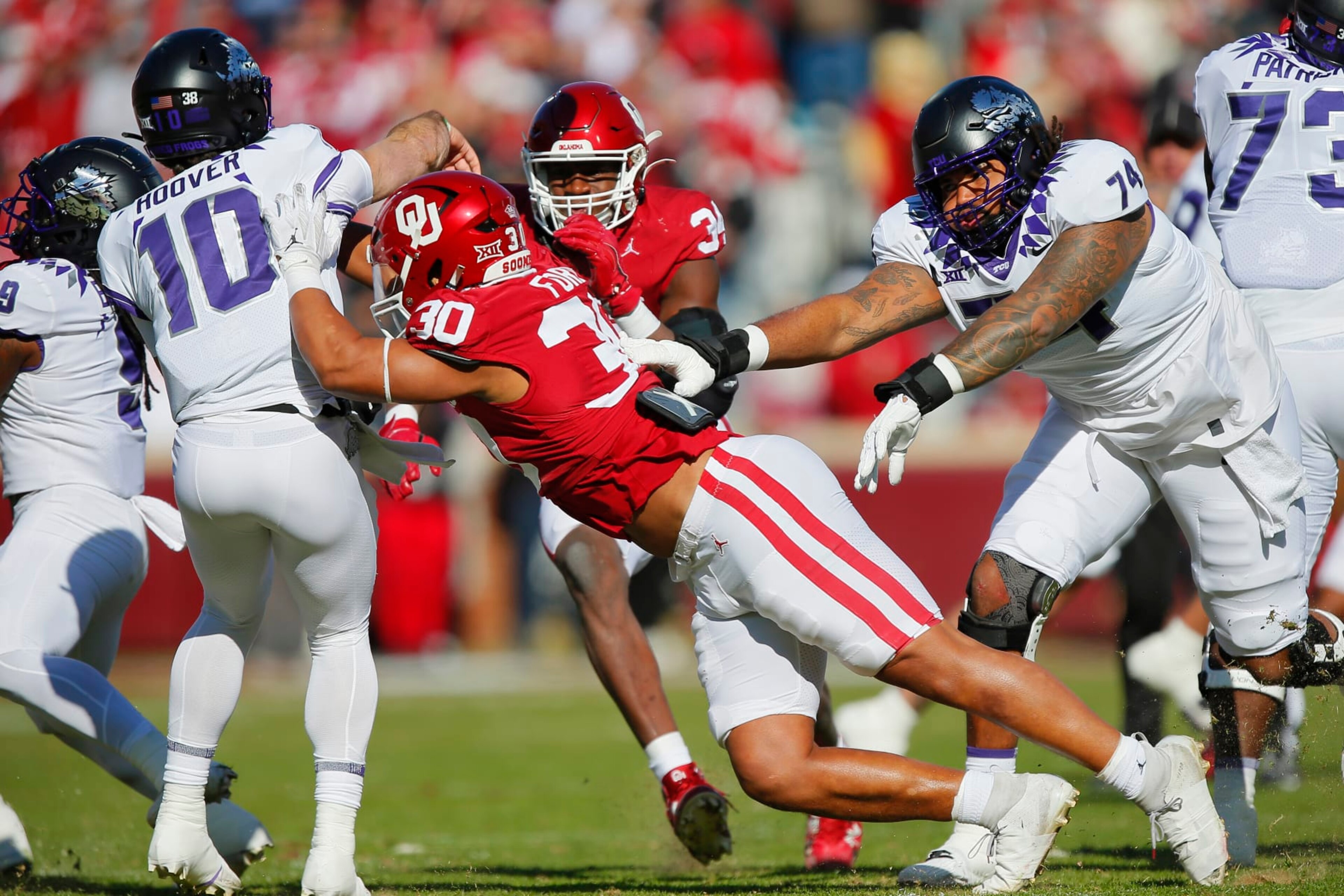 NORMAN, OKLAHOMA - NOVEMBER 24:  Defensive lineman Trace Ford #30 and defensive lineman Adepoju Adebawore #34 of the Oklahoma Sooners rush quarterback Josh Hoover #10 of the TCU Horned Frogs for an incomplete pass early in the first quarter at Gaylord Family Oklahoma Memorial Stadium on November 24, 2023 in Norman, Oklahoma.  Oklahoma won 69-45.  (Photo by Brian Bahr/Getty Images)