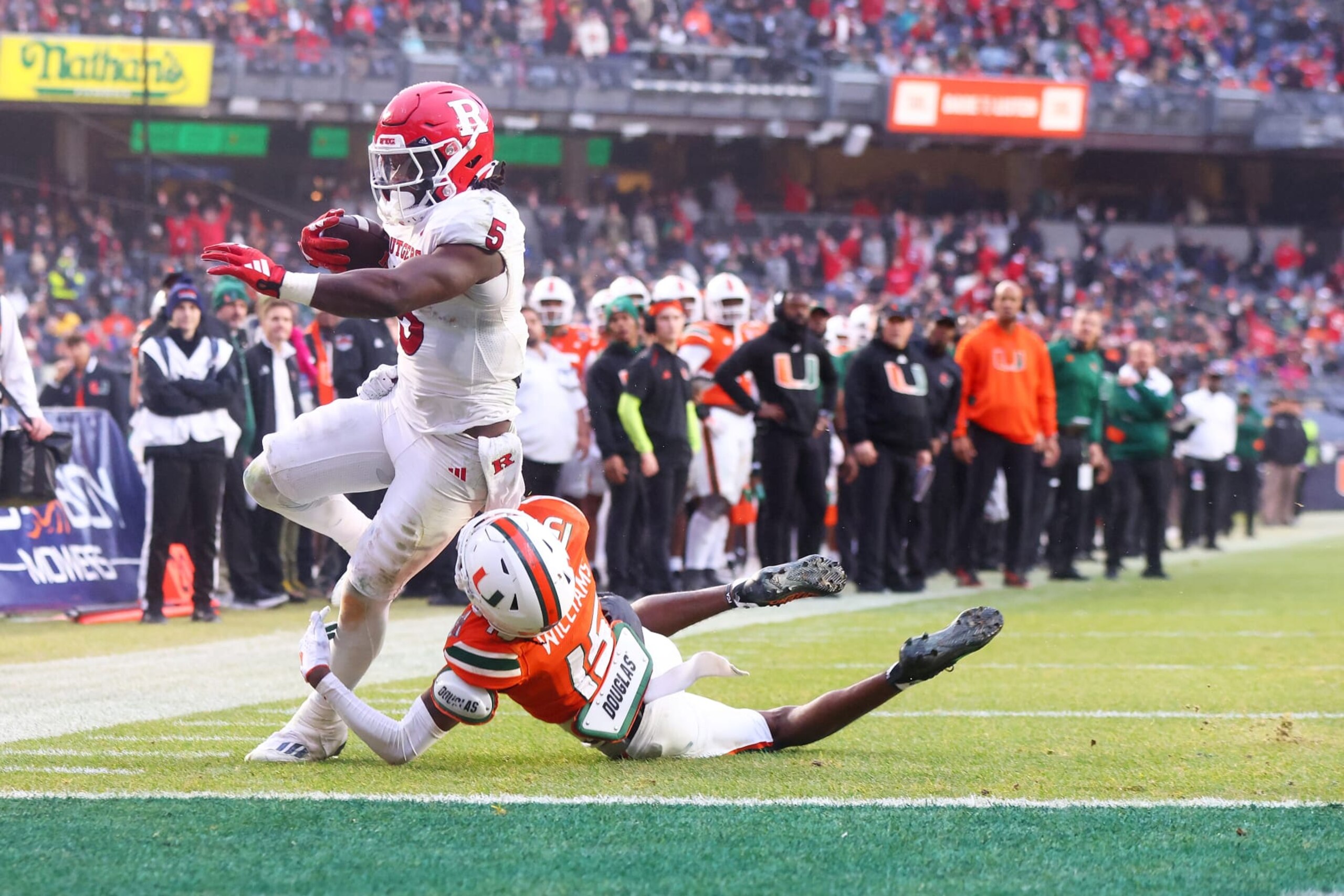 NEW YORK, NEW YORK - DECEMBER 28: Kyle Monangai #5 of the Rutgers Scarlet Knights rushes for a second quarter touchdown against Markeith Williams #15 of the Miami Hurricanes during the Bad Boy Mowers Pinstripe Bowl at Yankee Stadium on December 28, 2023 in New York City. (Photo by Mike Stobe/Getty Images) NEW YORK, NEW YORK - DECEMBER 28: Kyle Monangai #5 of the Rutgers Scarlet Knights rushes for a second quarter touchdown against Markeith Williams #15 of the Miami Hurricanes during the Bad Boy Mowers Pinstripe Bowl at Yankee Stadium on December 28, 2023 in New York City. (Photo by Mike Stobe/Getty Images)