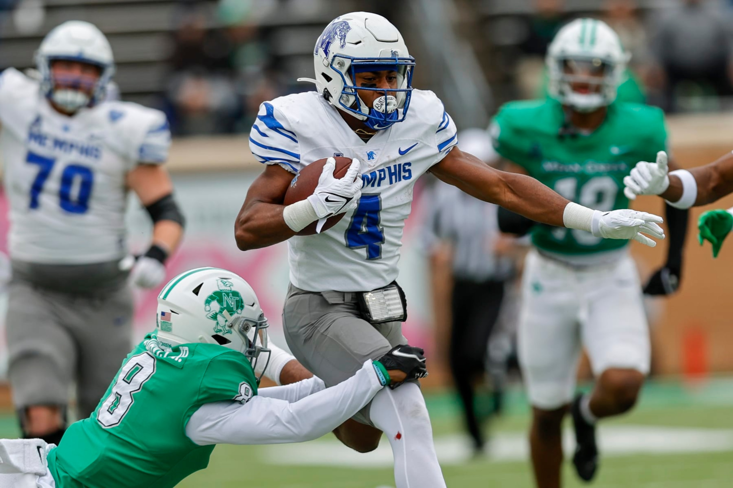 DENTON, TX - OCTOBER 28: Memphis Tigers running back Blake Watson (4) runs through North Texas Mean Green cornerback John Davis (8) during the game between the North Texas Mean Green and the Memphis Tigers on October 28, 2023 at DATCU Stadium in Denton, Texas. (Photo by Matthew Pearce/Icon Sportswire via Getty Images)
