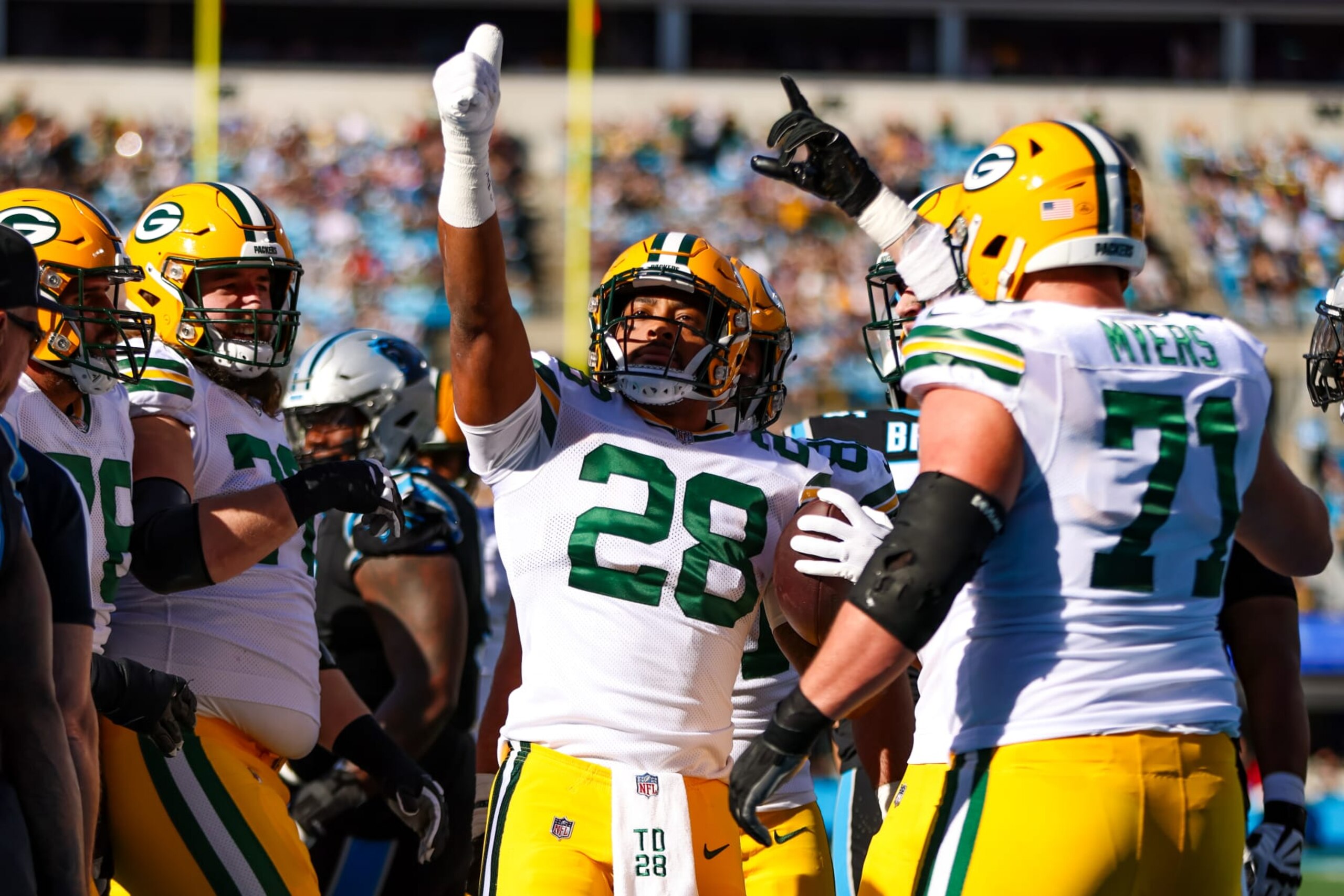 CHARLOTTE, NC - DECEMBER 24: AJ Dillon #28 of the Green Bay Packers celebrates after scoring a touchdown during an NFL game against the Carolina Panthers at Bank of America Stadium on December 24, 2023 in Charlotte, NC. (Photo by David Jensen/Icon Sportswire via Getty Images)