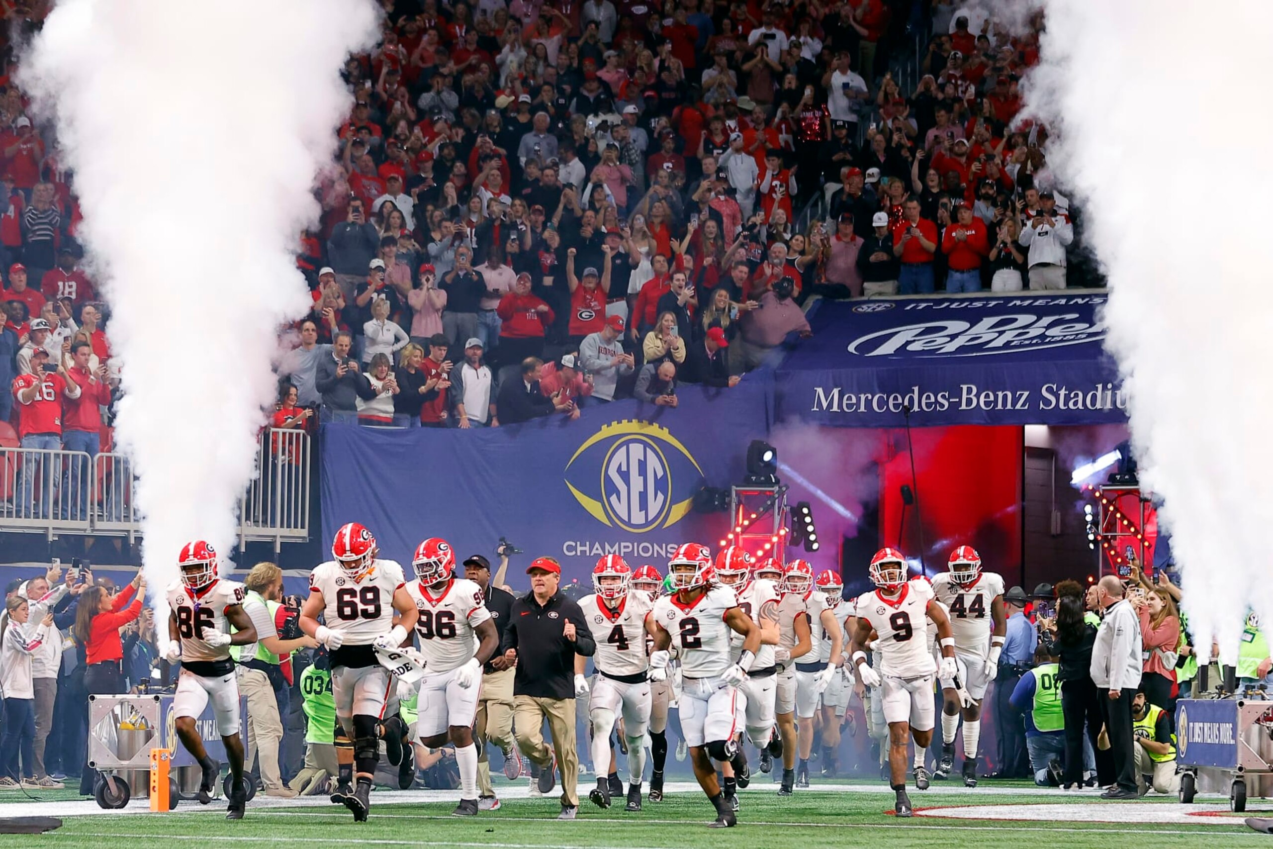 ATLANTA, GEORGIA - DECEMBER 02: Head coach Kirby Smart and the Georgia Bulldogs run onto the field during team introductions prior to the SEC Championship game against the Alabama Crimson Tide at Mercedes-Benz Stadium on December 02, 2023 in Atlanta, Georgia. (Photo by Todd Kirkland/Getty Images) ATLANTA, GEORGIA - DECEMBER 02: Head coach Kirby Smart and the Georgia Bulldogs run onto the field during team introductions prior to the SEC Championship game against the Alabama Crimson Tide at Mercedes-Benz Stadium on December 02, 2023 in Atlanta, Georgia. (Photo by Todd Kirkland/Getty Images)