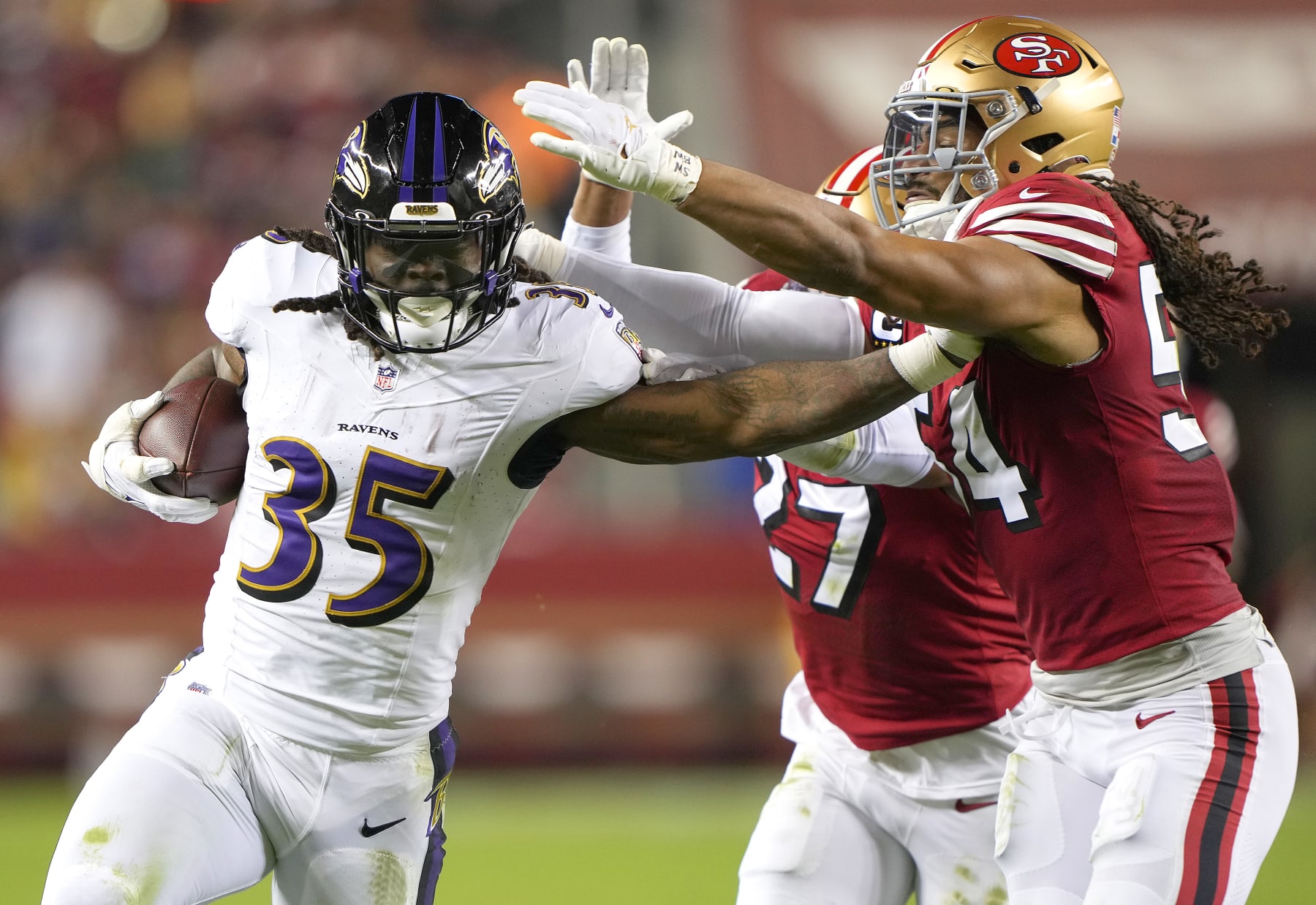 SANTA CLARA, CALIFORNIA - DECEMBER 25: Gus Edwards #35 of the Baltimore Ravens stiff arms Fred Warner #54 of the San Francisco 49ers during the third quarter at Levi's Stadium on December 25, 2023 in Santa Clara, California. (Photo by Thearon W. Henderson/Getty Images)