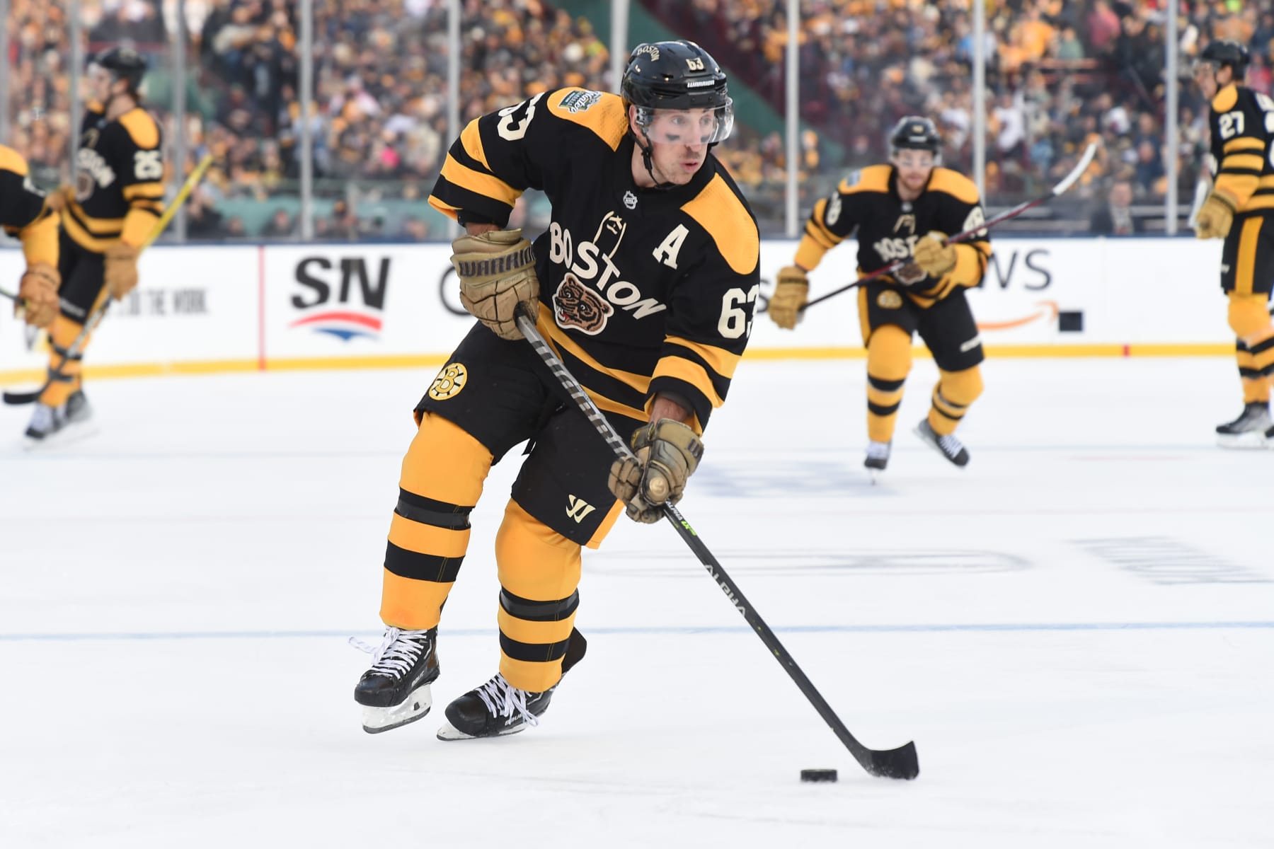 BOSTON, MASSACHUSETTS - JANUARY 2: Brad Marchand #63 of the Boston Bruins skates against the Pittsburgh Penguins at the 2023 Discover NHL Winter Classic at Fenway Park on January 2, 2023 in Boston, Massachusetts. (Photo by Steve Babineau/NHLI via Getty Images)