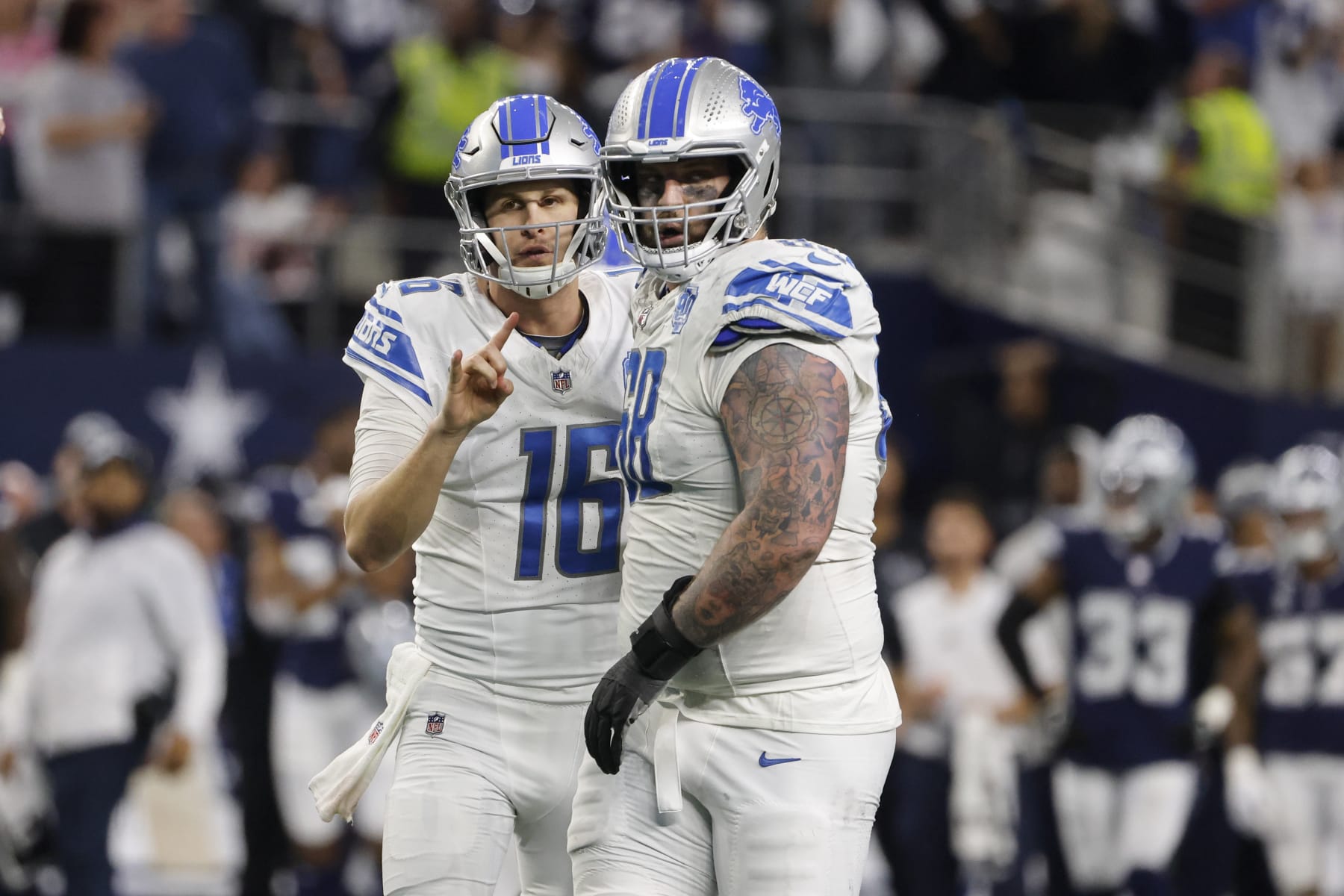 Detroit Lions quarterback Jared Goff, left, talks with offensive tackle Taylor Decker before running a 2-point conversion play against the Dallas Cowboys during the second half of an NFL football game, Saturday, Dec. 30, 2023, in Arlington, Texas. The Cowboys won 20-19. Decker caught a pass for the score on the play, but the score was annulled because he did not check in as an eligible receiver with officials prior to the play. (AP Photo/Michael Ainsworth)