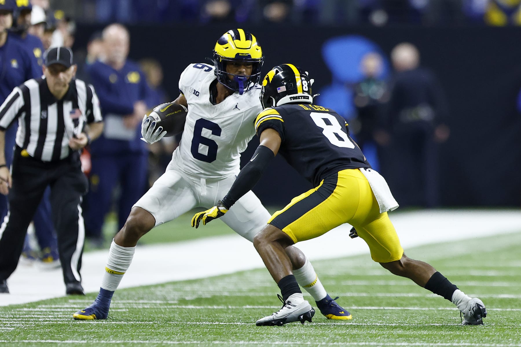 INDIANAPOLIS, IN - DECEMBER 02: Michigan Wolverines wide receiver Cornelius Johnson (6) stiff arms Iowa Hawkeyes defensive back Deshaun Lee (8) during the Big Ten Championship Game between the Michigan Wolverines and the Iowa Hawkeyes on December 02, 2023 at Lucas Oil Stadium in Indianapolis,IN.  (Photo by Jeffrey Brown/Icon Sportswire via Getty Images)