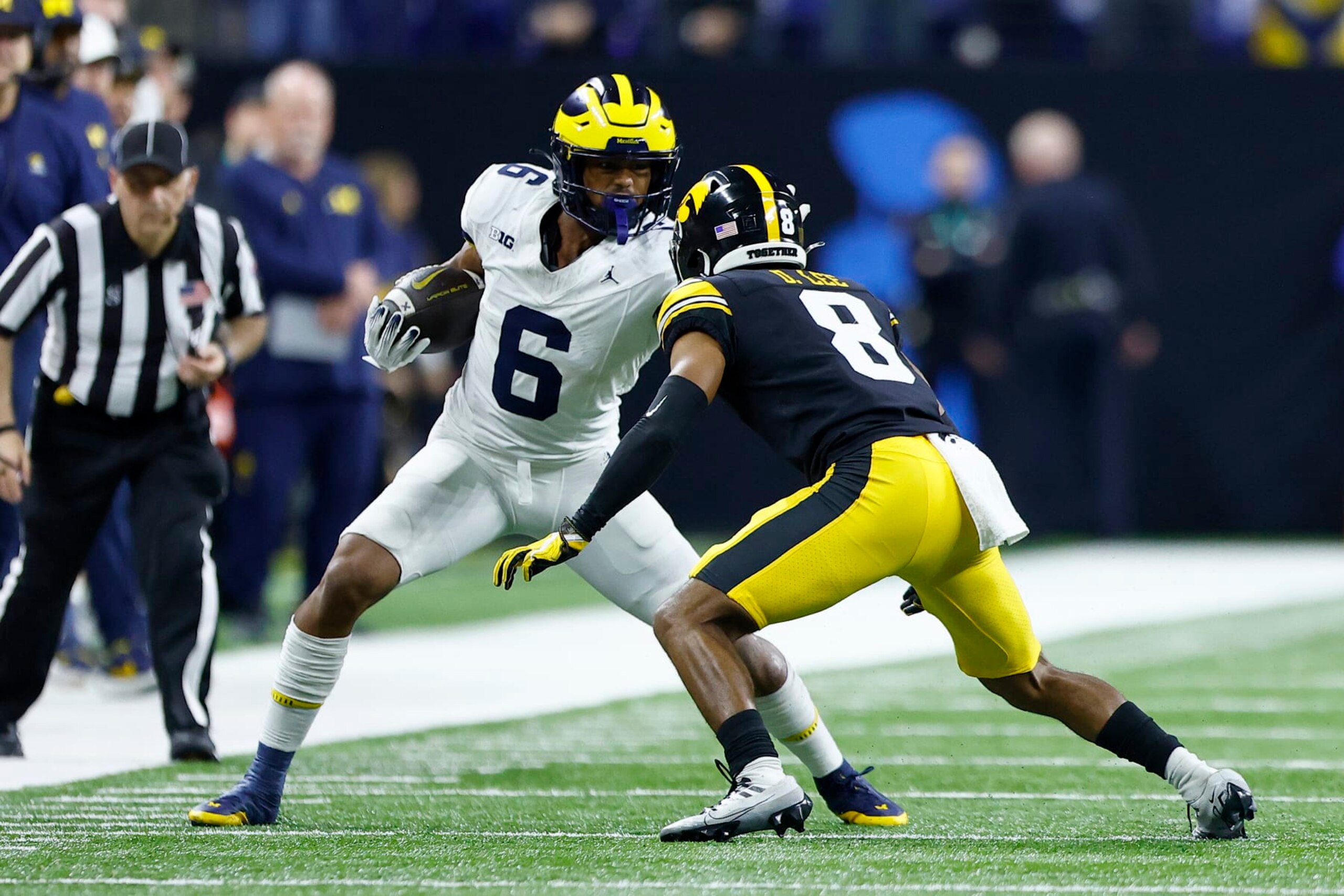 INDIANAPOLIS, IN - DECEMBER 02: Michigan Wolverines wide receiver Cornelius Johnson (6) stiff arms Iowa Hawkeyes defensive back Deshaun Lee (8) during the Big Ten Championship Game between the Michigan Wolverines and the Iowa Hawkeyes on December 02, 2023 at Lucas Oil Stadium in Indianapolis,IN.  (Photo by Jeffrey Brown/Icon Sportswire via Getty Images)