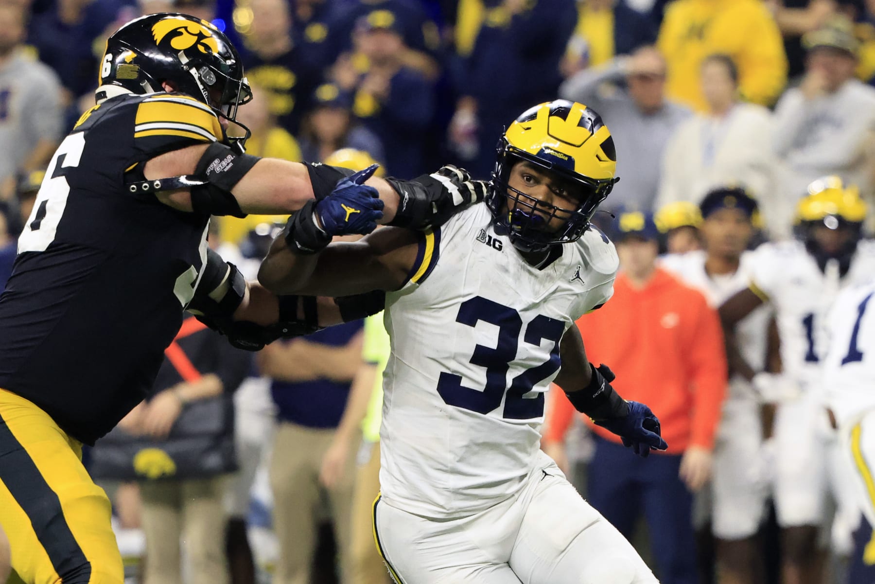 INDIANAPOLIS, INDIANA - DECEMBER 02: Jaylen Harrell #32 of the Michigan Wolverines makes a move on Nick DeJong #56 of the Iowa Hawkeyes during the Big Ten Championship at Lucas Oil Stadium on December 02, 2023 in Indianapolis, Indiana. (Photo by Justin Casterline/Getty Images)