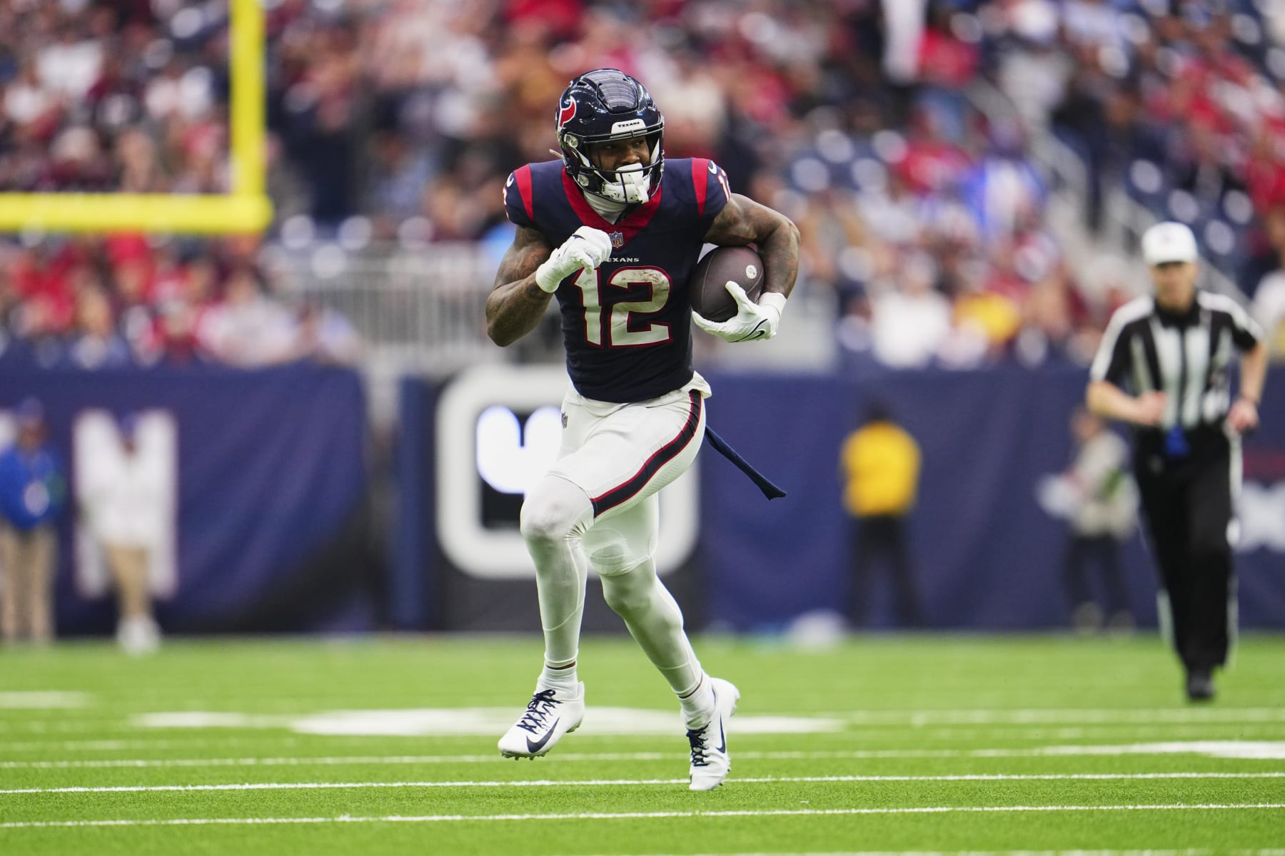 HOUSTON, TX - DECEMBER 31: Nico Collins #12 of the Houston Texans runs with the ball after a catch against the Tennessee Titans during the second half at NRG Stadium on December 31, 2023 in Houston, Texas. (Photo by Cooper Neill/Getty Images)