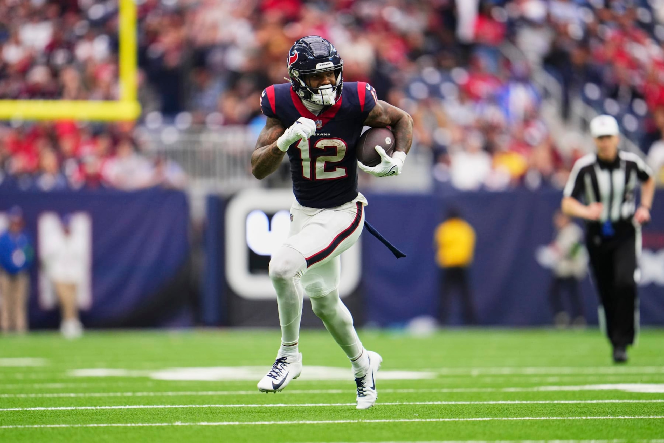 HOUSTON, TX - DECEMBER 31: Nico Collins #12 of the Houston Texans runs with the ball after a catch against the Tennessee Titans during the second half at NRG Stadium on December 31, 2023 in Houston, Texas. (Photo by Cooper Neill/Getty Images)