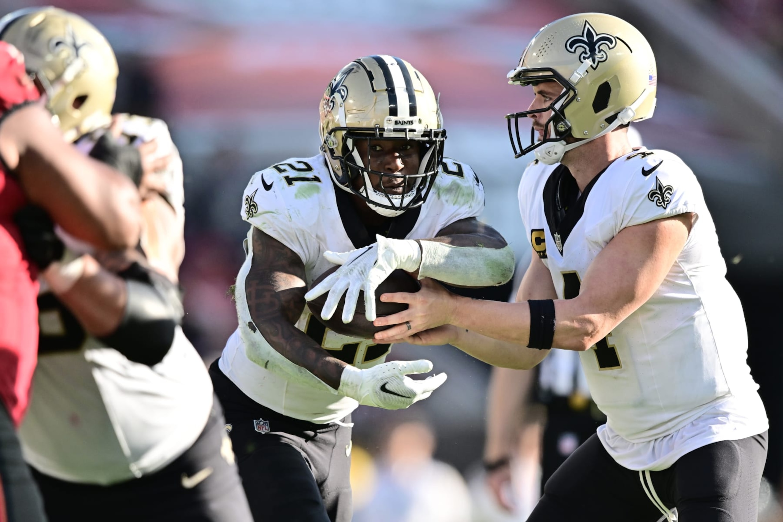TAMPA, FLORIDA - DECEMBER 31: Derek Carr #4 hands off the ball to Jamaal Williams #21 of the New Orleans Saints during the fourth quarter against the Tampa Bay Buccaneers at Raymond James Stadium on December 31, 2023 in Tampa, Florida. (Photo by Julio Aguilar/Getty Images)