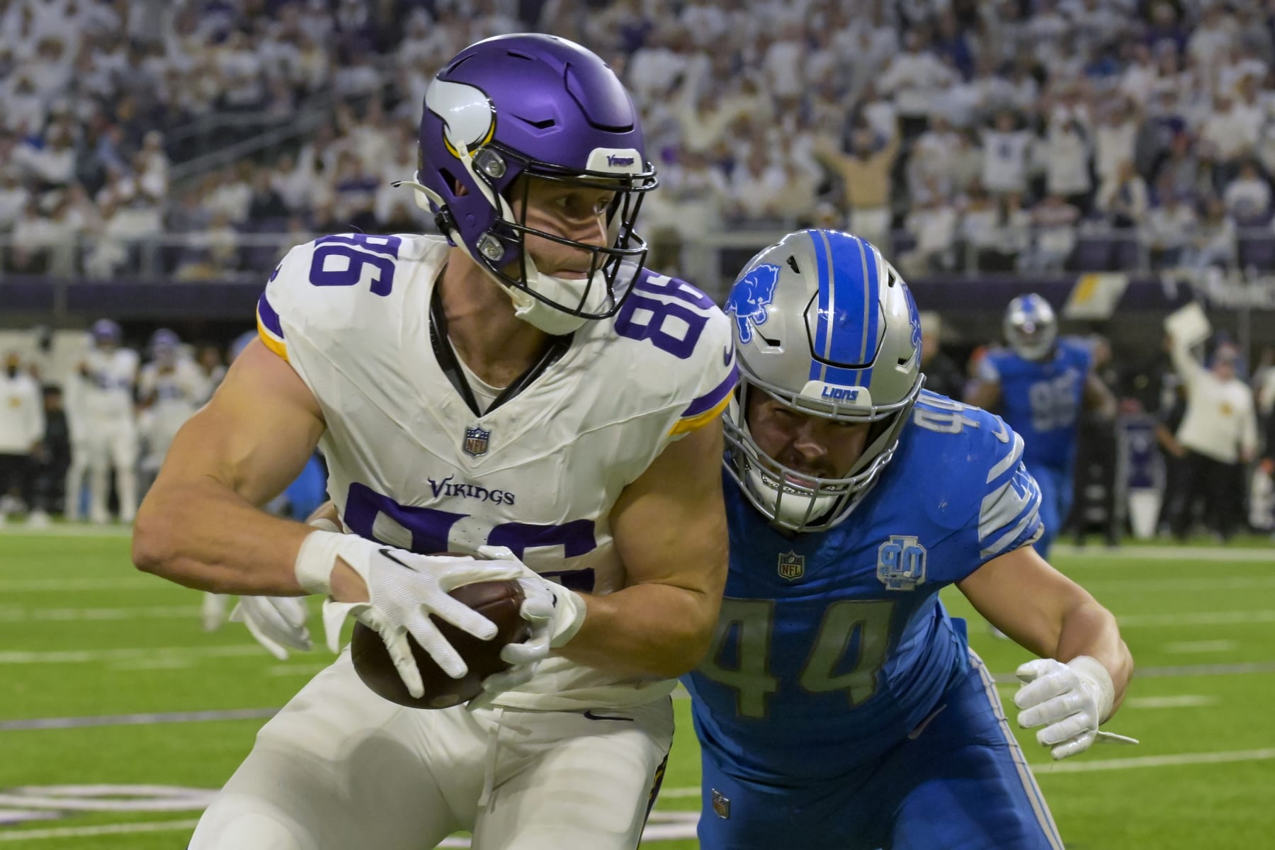 MINNEAPOLIS, MN - DECEMBER 24: Minnesota Vikings tight end Johnny Mundt (86) runs with the ball after the catch as Detroit Lions linebacker Malcolm Rodriguez (44) goes to wrap him up during the fourth quarter of an NFL game between the Minnesota Vikings and Detroit Lions on December 24, 2023, at U.S. Bank Stadium in Minneapolis, MN. (Photo by Nick Wosika/Icon Sportswire via Getty Images)