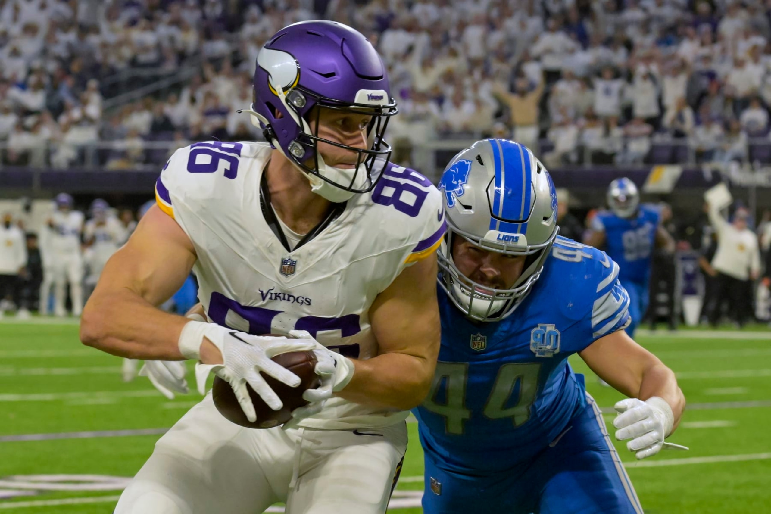 MINNEAPOLIS, MN - DECEMBER 24: Minnesota Vikings tight end Johnny Mundt (86) runs with the ball after the catch as Detroit Lions linebacker Malcolm Rodriguez (44) goes to wrap him up during the fourth quarter of an NFL game between the Minnesota Vikings and Detroit Lions on December 24, 2023, at U.S. Bank Stadium in Minneapolis, MN. (Photo by Nick Wosika/Icon Sportswire via Getty Images) MINNEAPOLIS, MN - DECEMBER 24: Minnesota Vikings tight end Johnny Mundt (86) runs with the ball after the catch as Detroit Lions linebacker Malcolm Rodriguez (44) goes to wrap him up during the fourth quarter of an NFL game between the Minnesota Vikings and Detroit Lions on December 24, 2023, at U.S. Bank Stadium in Minneapolis, MN. (Photo by Nick Wosika/Icon Sportswire via Getty Images)