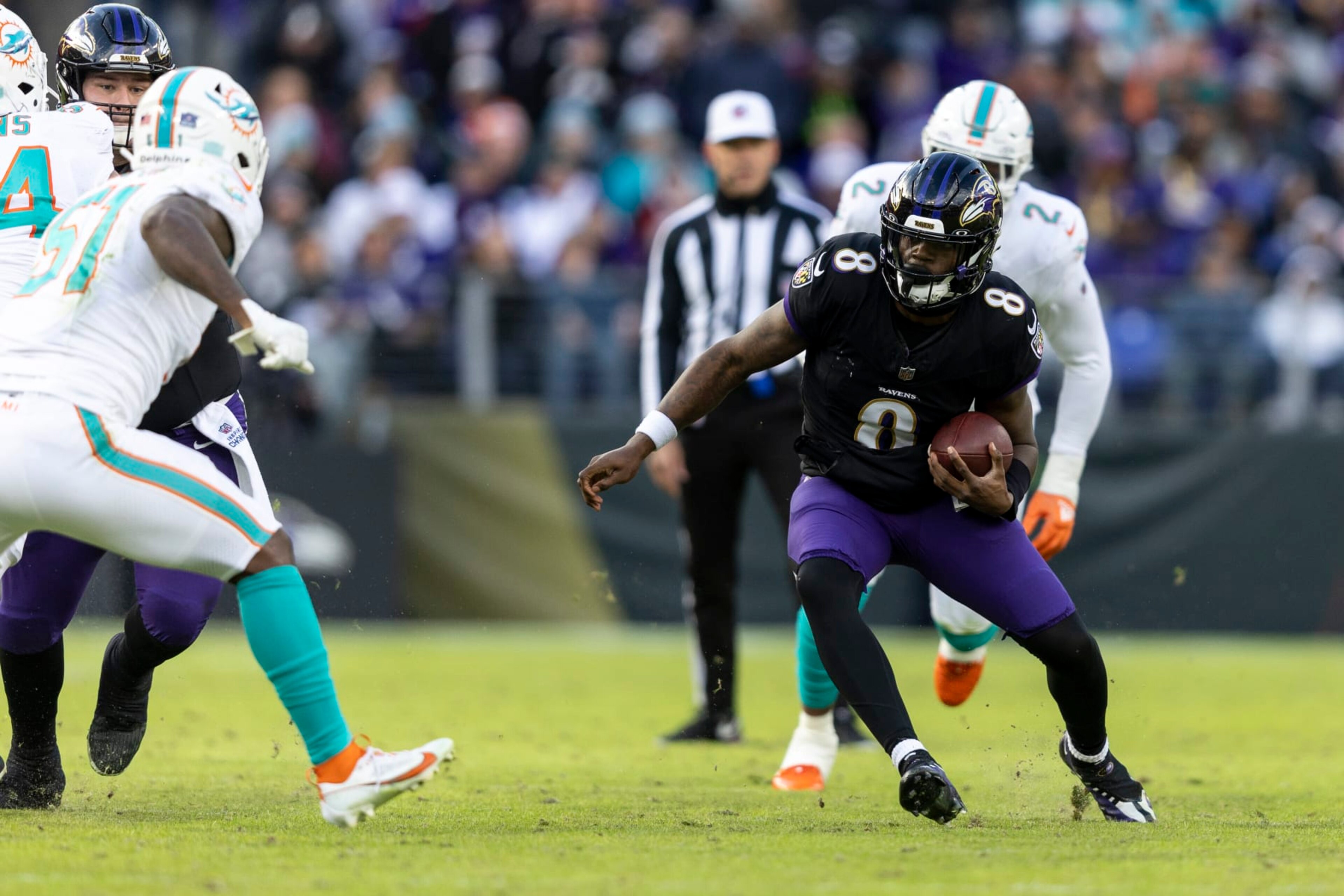 BALTIMORE, MARYLAND - DECEMBER 31: Lamar Jackson #8 of the Baltimore Ravens runs with the ball during an NFL football game between the Baltimore Ravens and the Miami Dolphins at M&T Bank Stadium on December 31, 2023 in Baltimore, Maryland. (Photo by Michael Owens/Getty Images)