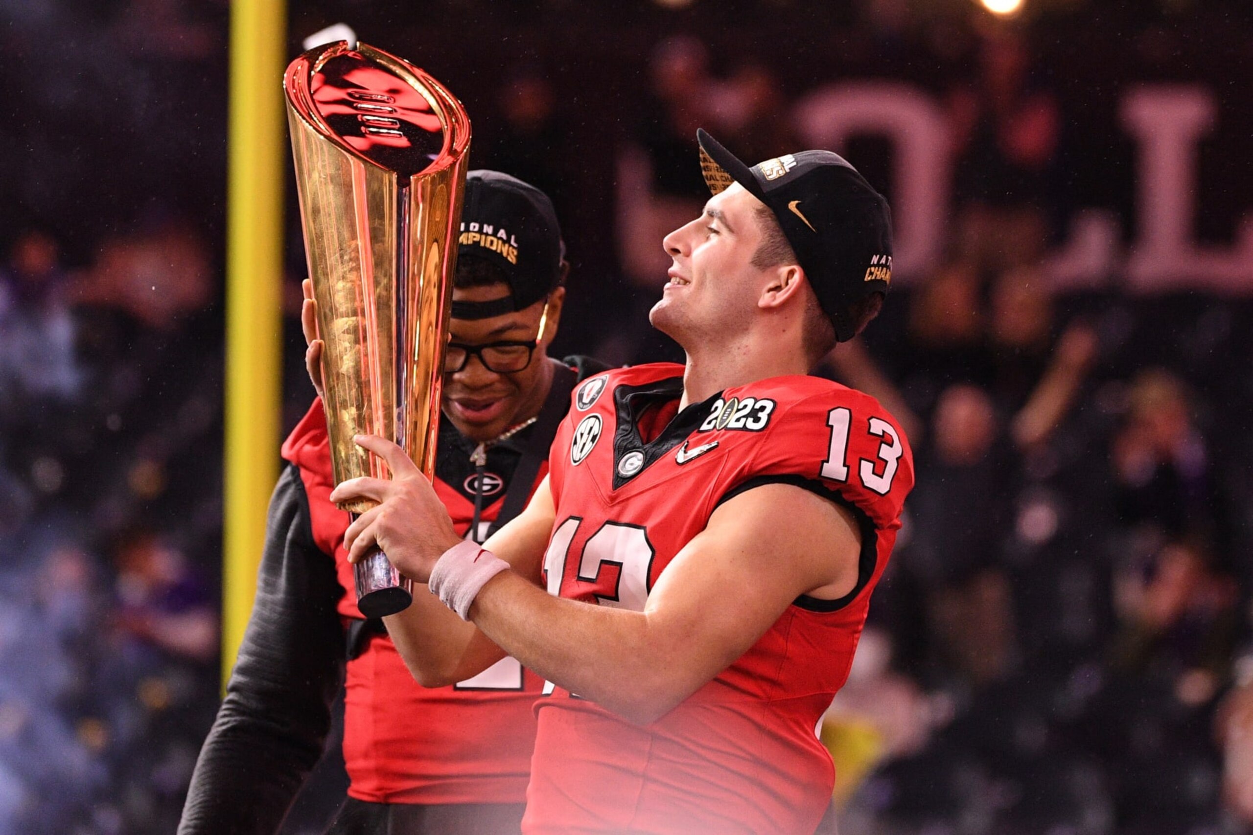 INGLEWOOD, CA - JANUARY 09: Georgia Bulldogs quarterback Stetson Bennett (13) holds up the trophy after the Georgia Bulldogs game versus the TCU Horned Frogs in the College Football Playoff National Championship game on January 9, 2023, at SoFi Stadium in Inglewood, CA. (Photo by Brian Rothmuller/Icon Sportswire via Getty Images) INGLEWOOD, CA - JANUARY 09: Georgia Bulldogs quarterback Stetson Bennett (13) holds up the trophy after the Georgia Bulldogs game versus the TCU Horned Frogs in the College Football Playoff National Championship game on January 9, 2023, at SoFi Stadium in Inglewood, CA. (Photo by Brian Rothmuller/Icon Sportswire via Getty Images)