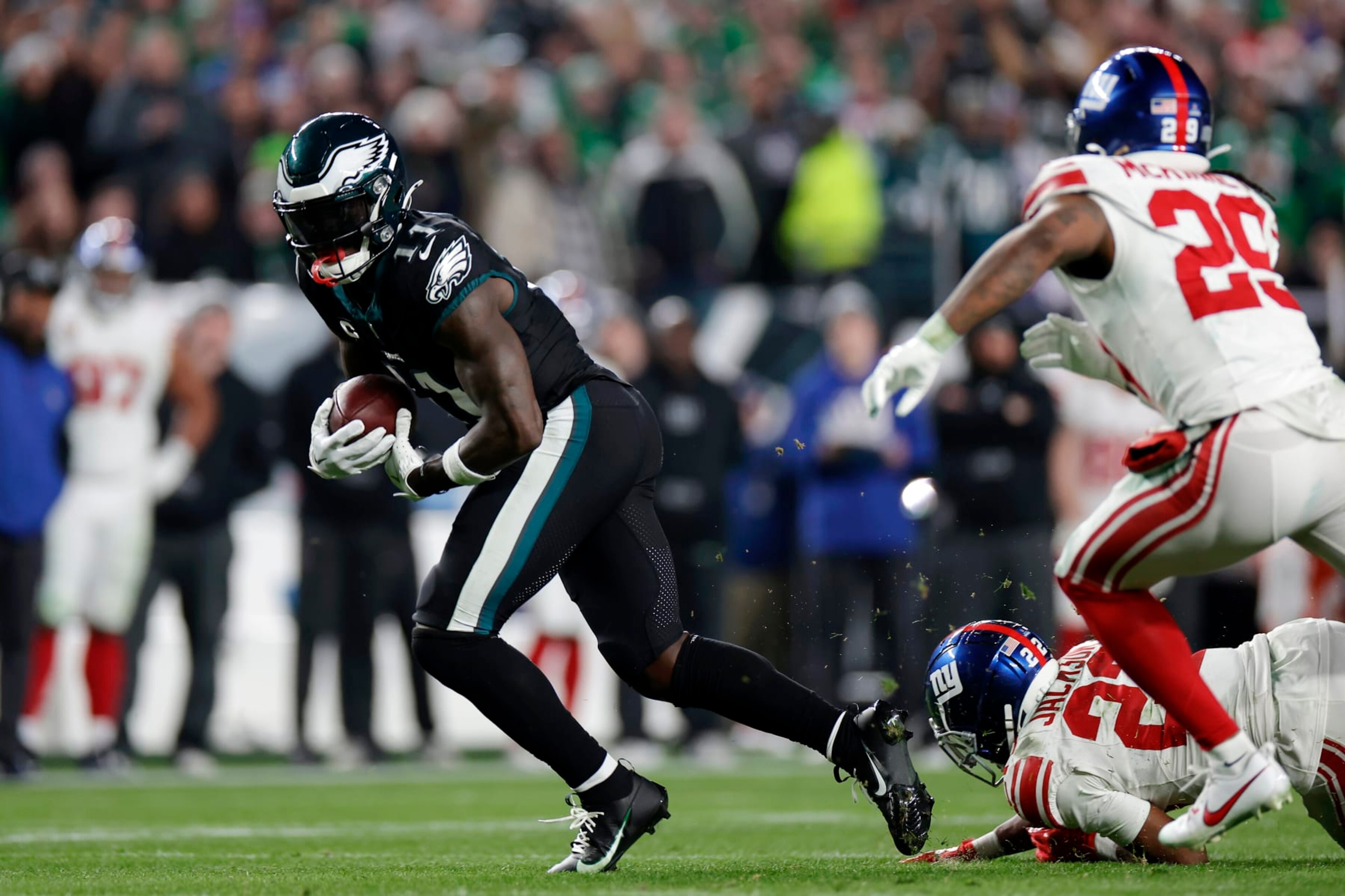PHILADELPHIA, PENNSYLVANIA - DECEMBER 25: A.J. Brown #11 of the Philadelphia Eagles runs the ball against Adoree' Jackson #22 and Xavier McKinney #29 of the New York Giants during the fourth quarter at Lincoln Financial Field on December 25, 2023 in Philadelphia, Pennsylvania. (Photo by Adam Hunger/Getty Images)