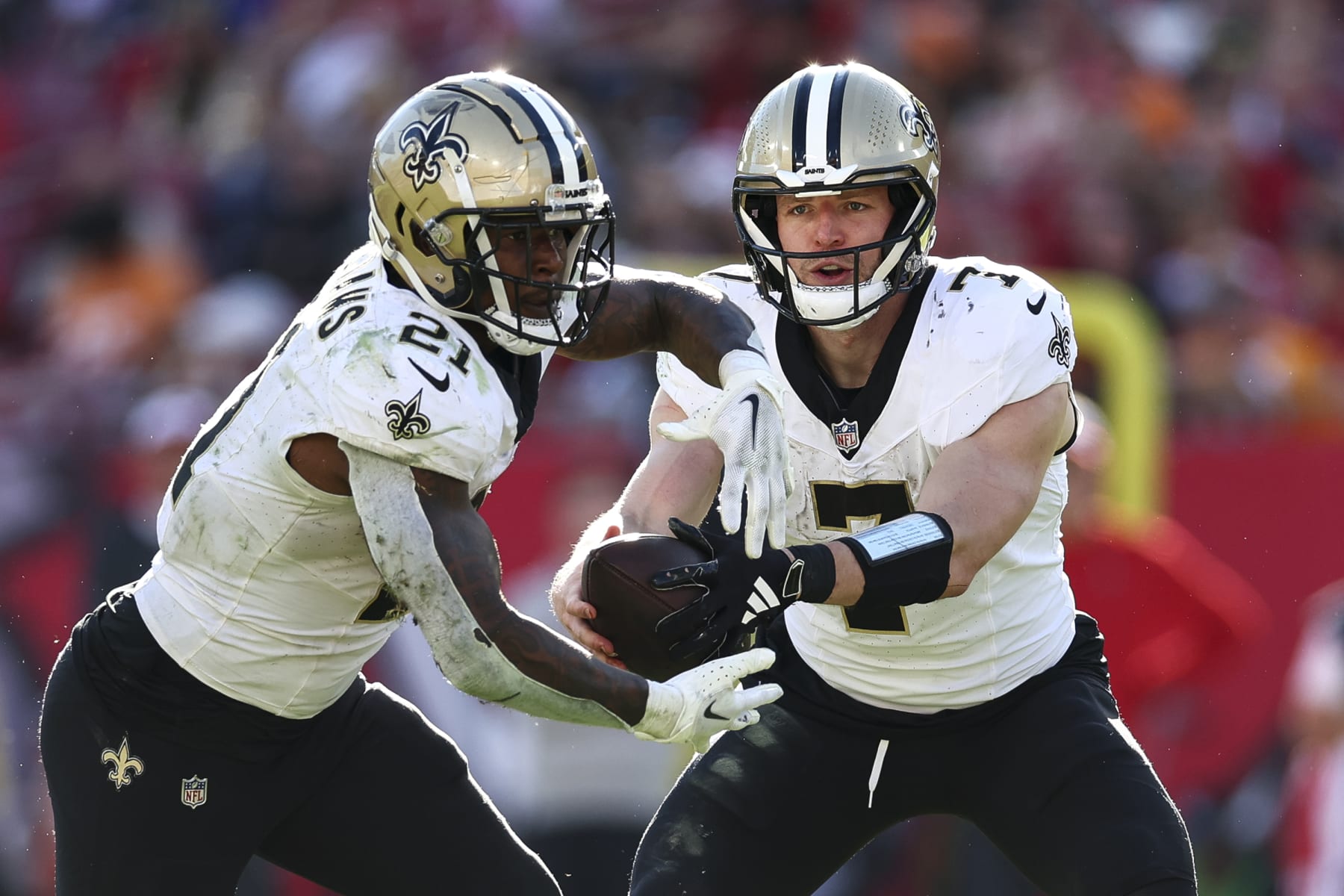 TAMPA, FL - DECEMBER 31: Taysom Hill #7 of the New Orleans Saints hands the ball off to Jamaal Williams #21 during the fourth quarter of an NFL football game at Raymond James Stadium on December 31, 2023 in Tampa, Florida. (Photo by Kevin Sabitus/Getty Images)